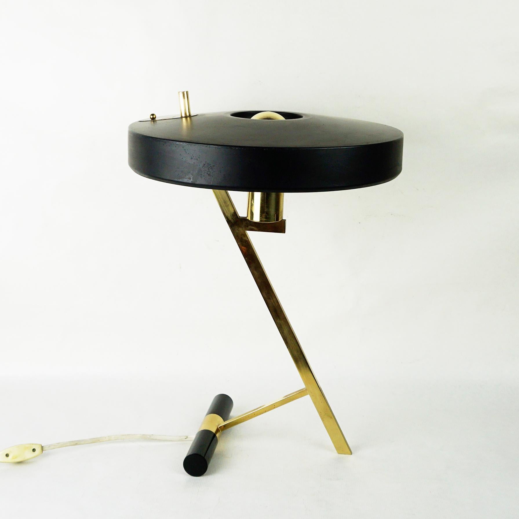 One of the most Iconic Dutch mid-century desk or table lamps designed by architect Louis Kalff for the Philips Company Holland.
It features a enameled black aluminium shade sitting on a z-shaped solid brass frame and base with one E 27