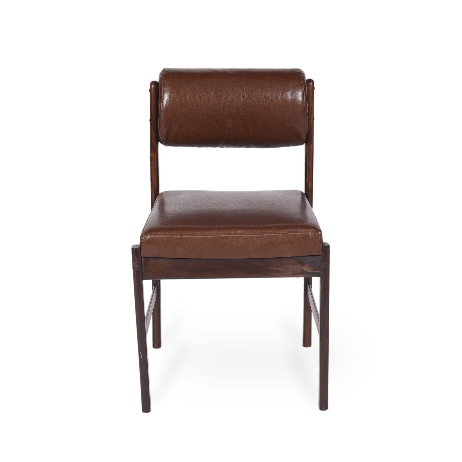 Midcentury Brazilian chair with wood structure and faux leather, 1960s.

Set of comfortable chairs in unidentified wood and faux leather seat.