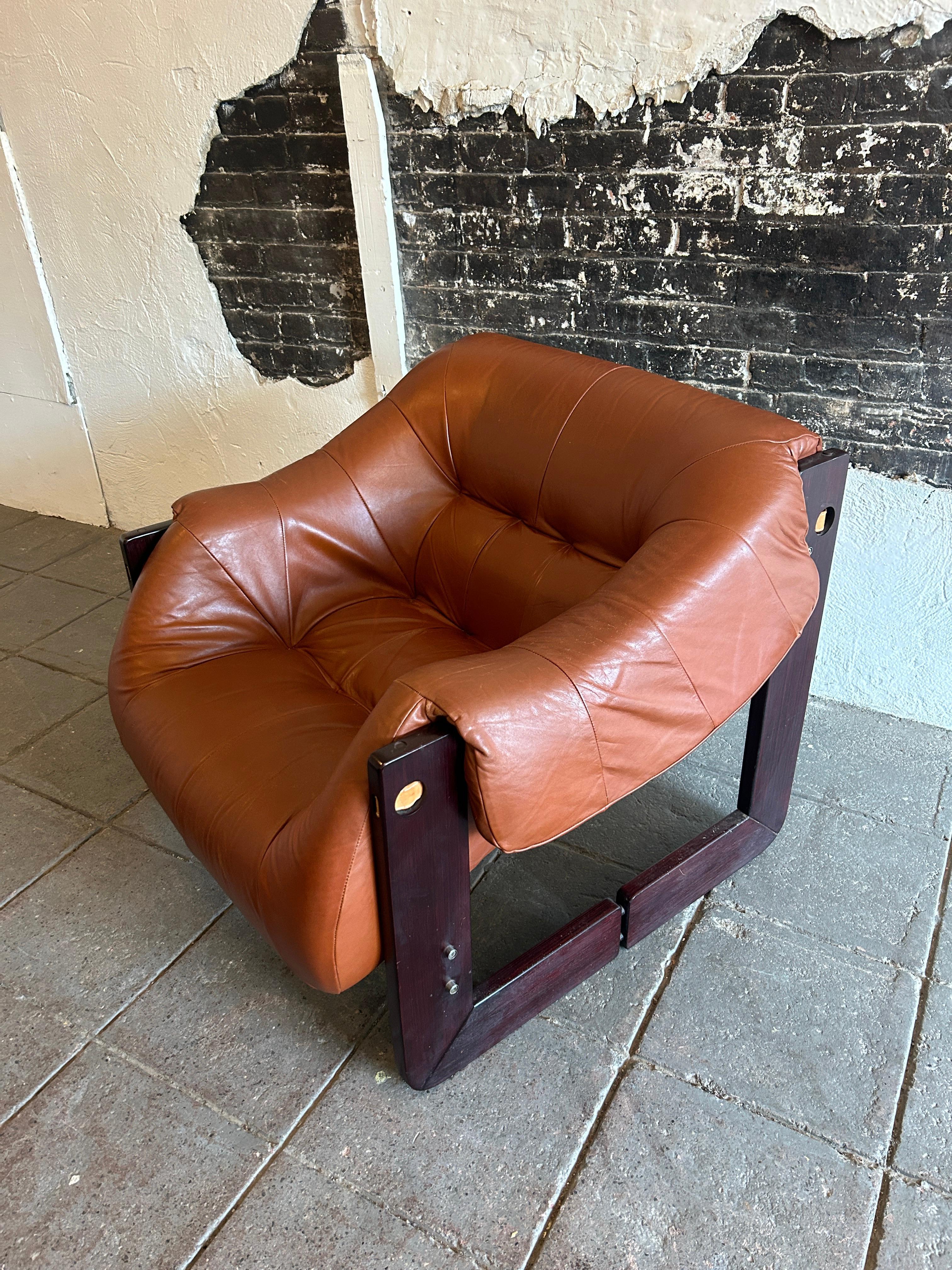 Superb cognac all original leather lounge chair by Percival Lafer - model MP-97. This beautiful chair is made of a Brazilian hardwood frame with saddle leather straps and a cognac leather cushion. The seat cushions are all original beautiful cognac