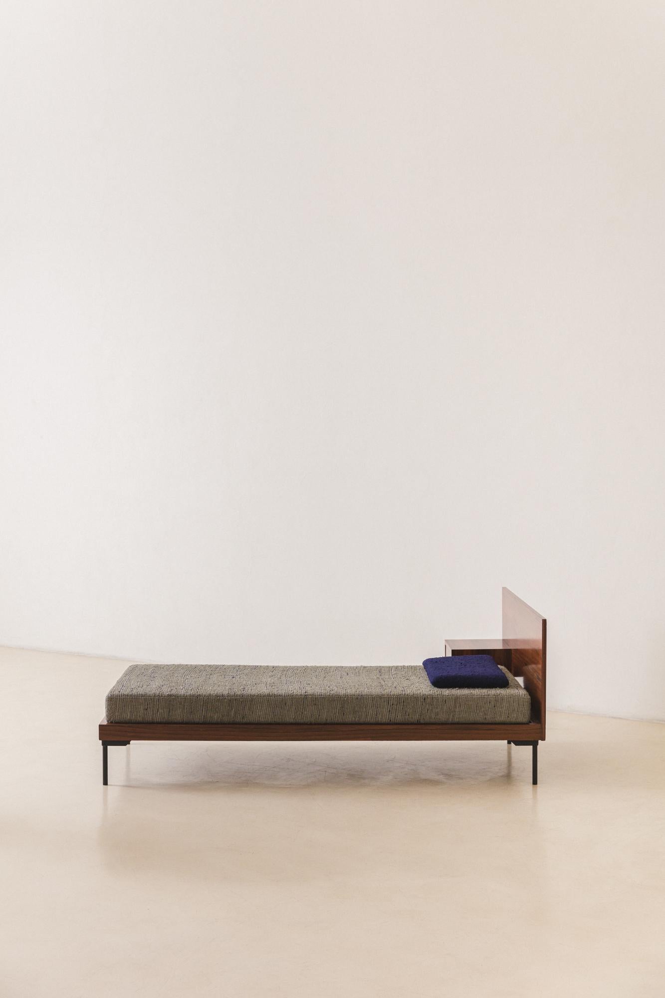 The MF 2013 is a single bed signed by the pioneer company Unilabor in c. 1954, with design by Geraldo de Barros (1923-1998).

The piece is composed of a wood structure with Rosewood veneers and four iron feet with brass tips. The headboard has a