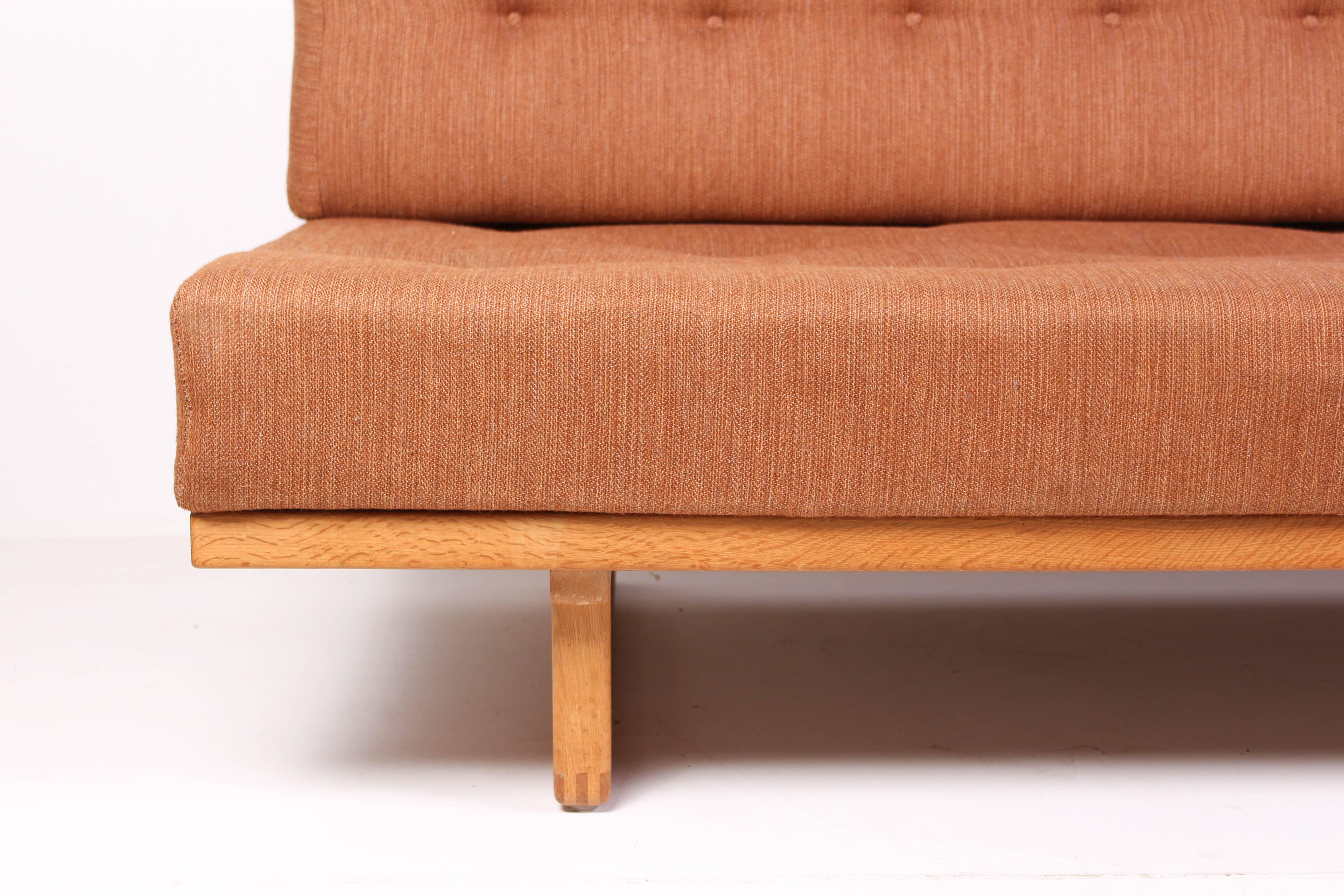 This daybed was designed in 1958 by Danish designer Børge Mogensen and produced by Fredericia Stolefabrik, the model number is 312. It is made out of a solid oak frame with tufted cushions upholstered with wool fabric and brass fittings. The daybed