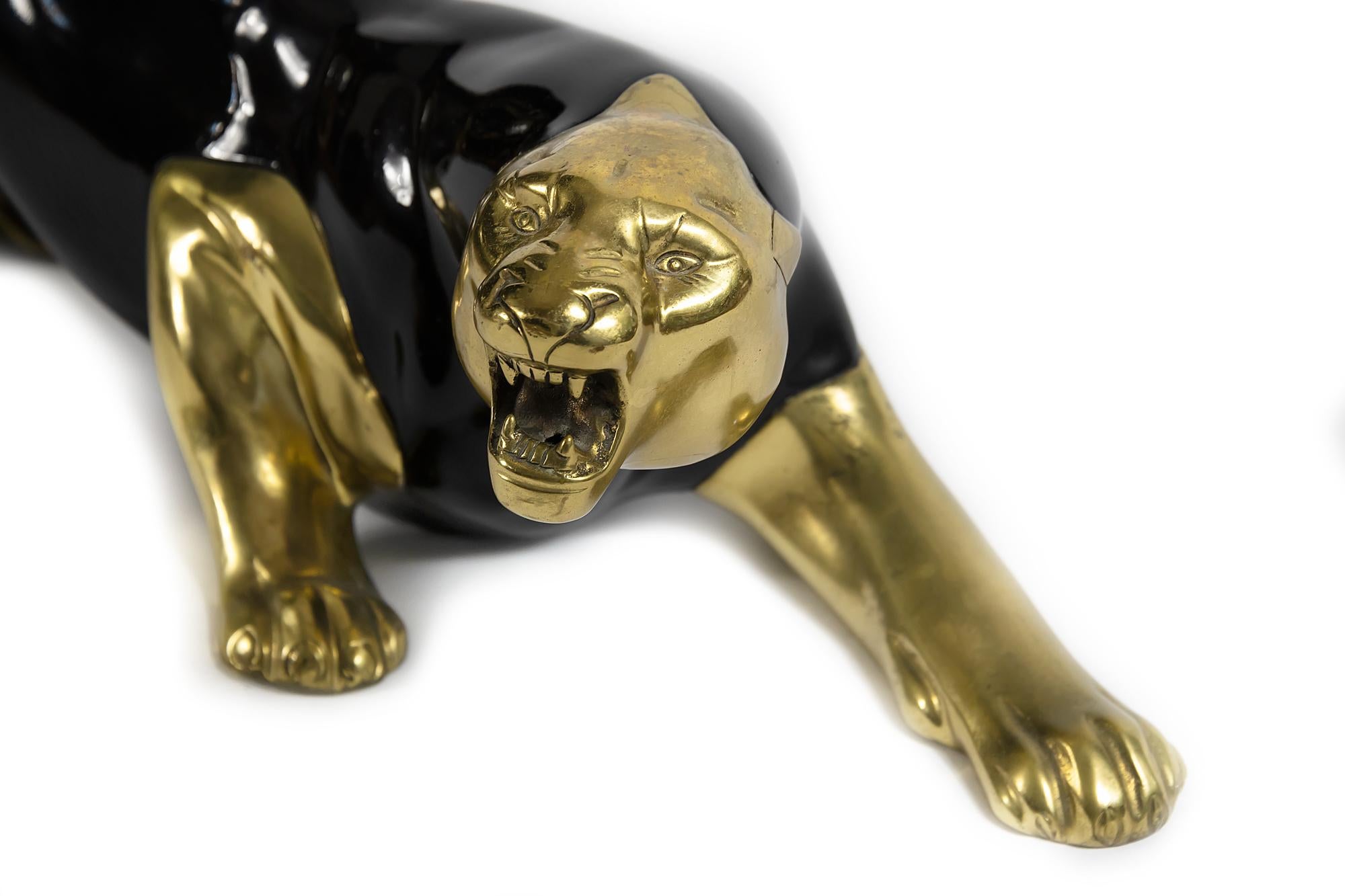 Midcentury panther sculpture is designed in bronze and decorated with black enamel. It is very solid and heavy.