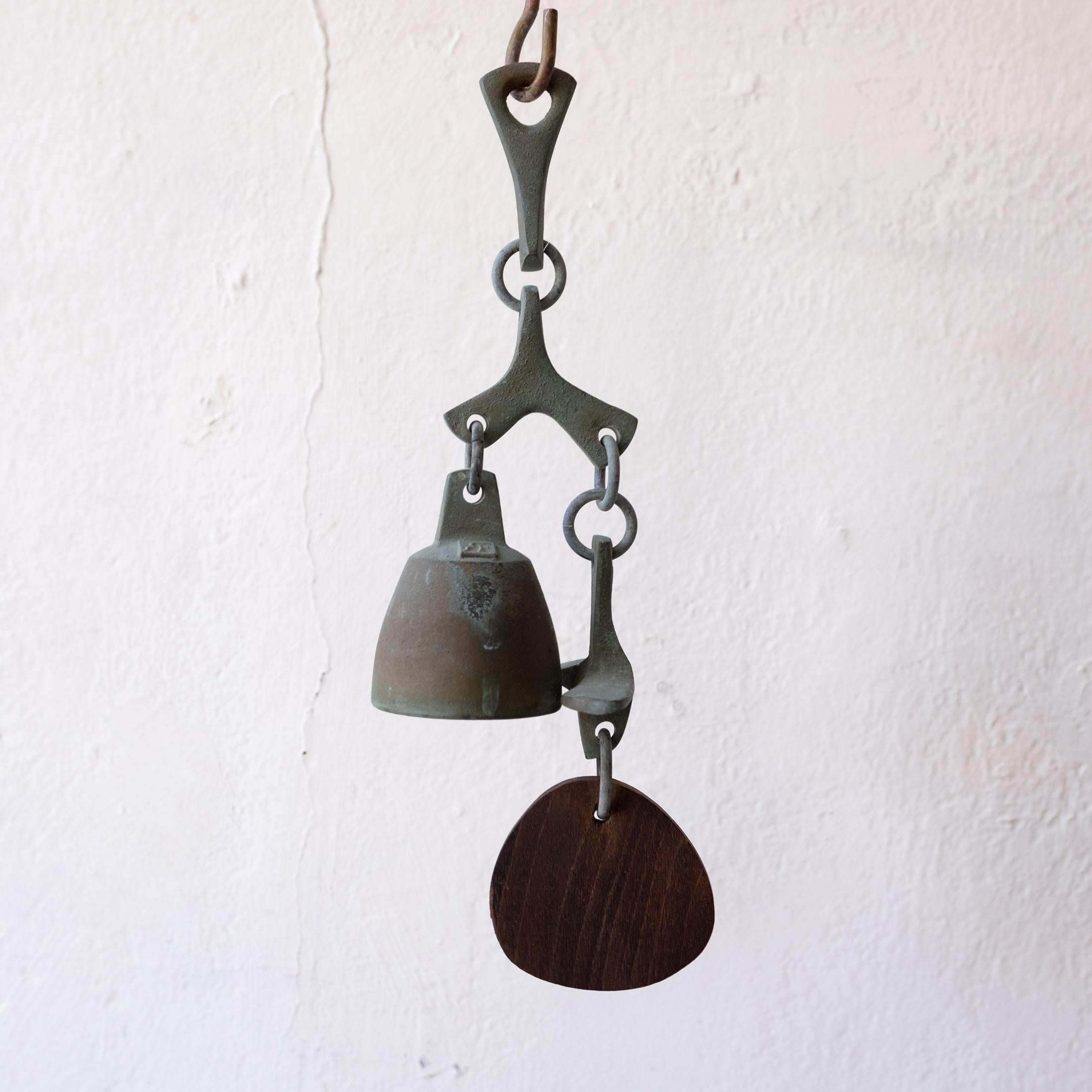 Solid bronze bell with a wood wind catcher. Years of nice patina. Could be used as a doorbell. It has a beautiful pitch.