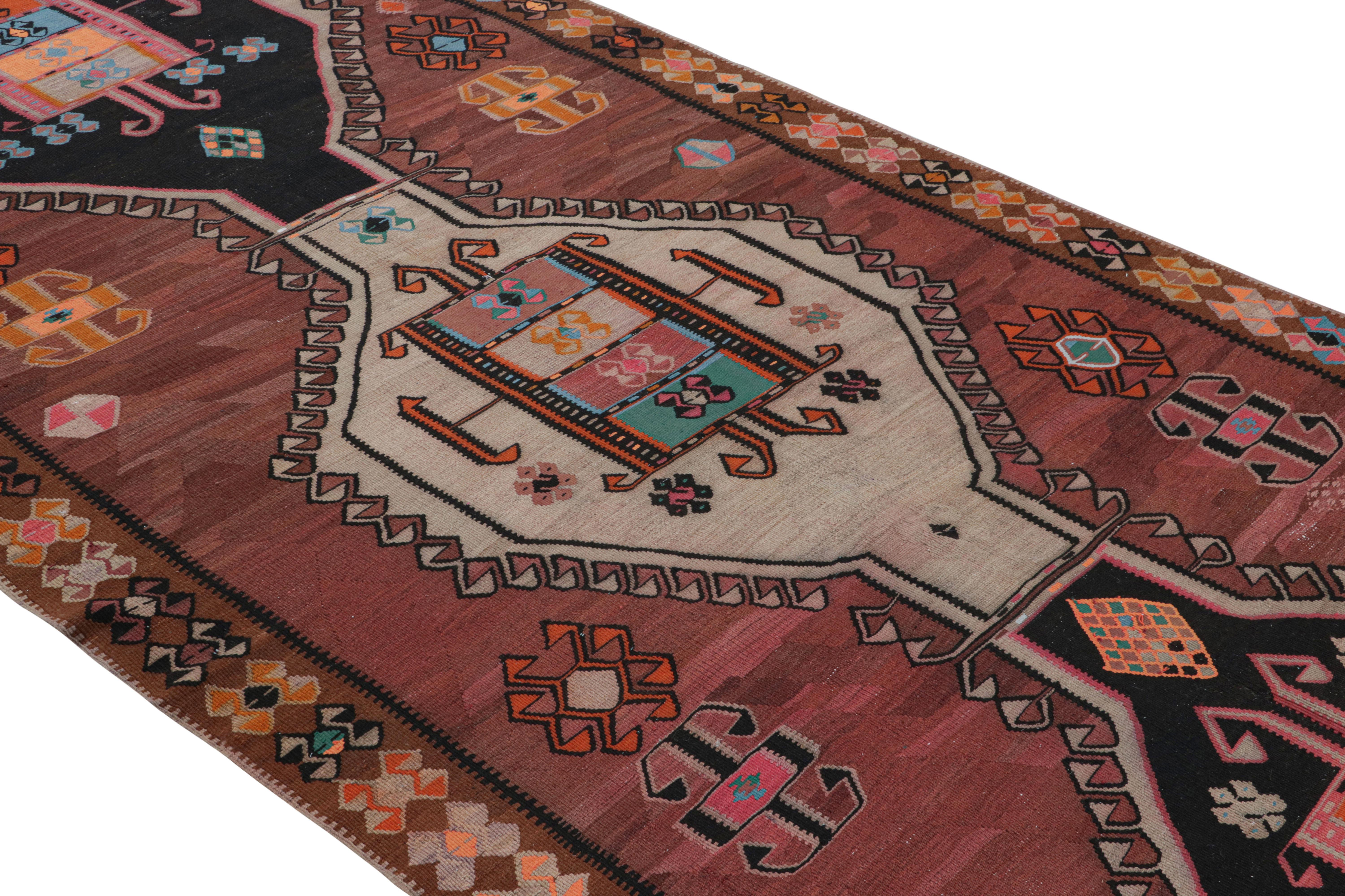A midcentury vintage tribal kilim, this piece originated in Turkey, handwoven between 1950-1960. The vintage Turkish flat-weave rug comprises wool in a colorway that reads primarily brown, black and beige, rich earth tones bringing out a pleasing