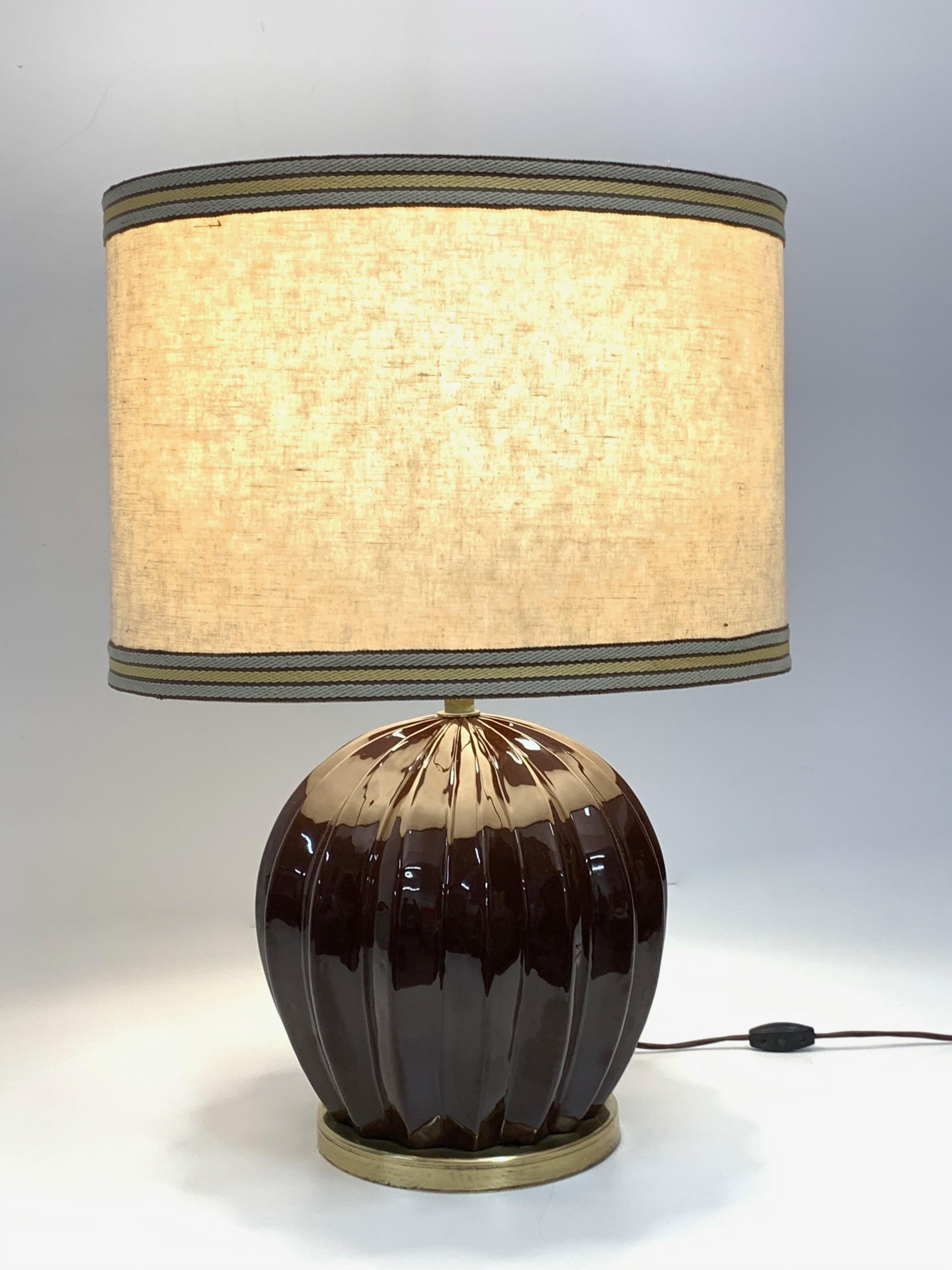 Iconic and large midcentury brown glazed ceramic lamp with white fabric shade. It was produced in Italy during 1970s and it is attributed to Tommaso Barbi.

The brown ceramic body with its lines, reminding cloves, and its brass like base, it is a