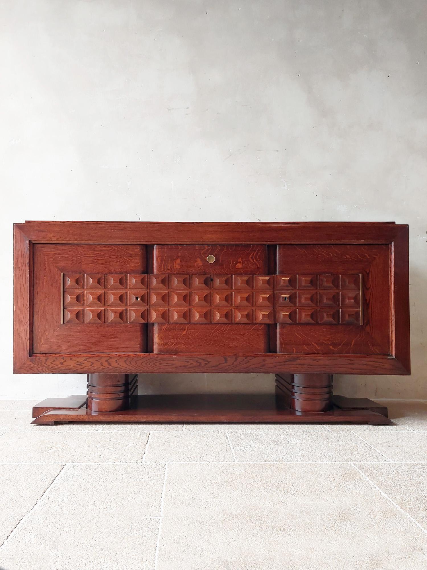 Midcentury brown oak sideboard by Charles Dudouyt, 1940s. Beautiful sideboard in pre-Brutalist Art Deco style decorated with typical geometric shapes of Dudouyt. The base gives this sideboard an extra sturdy character.

Dimensions: H 101 x W 200 x