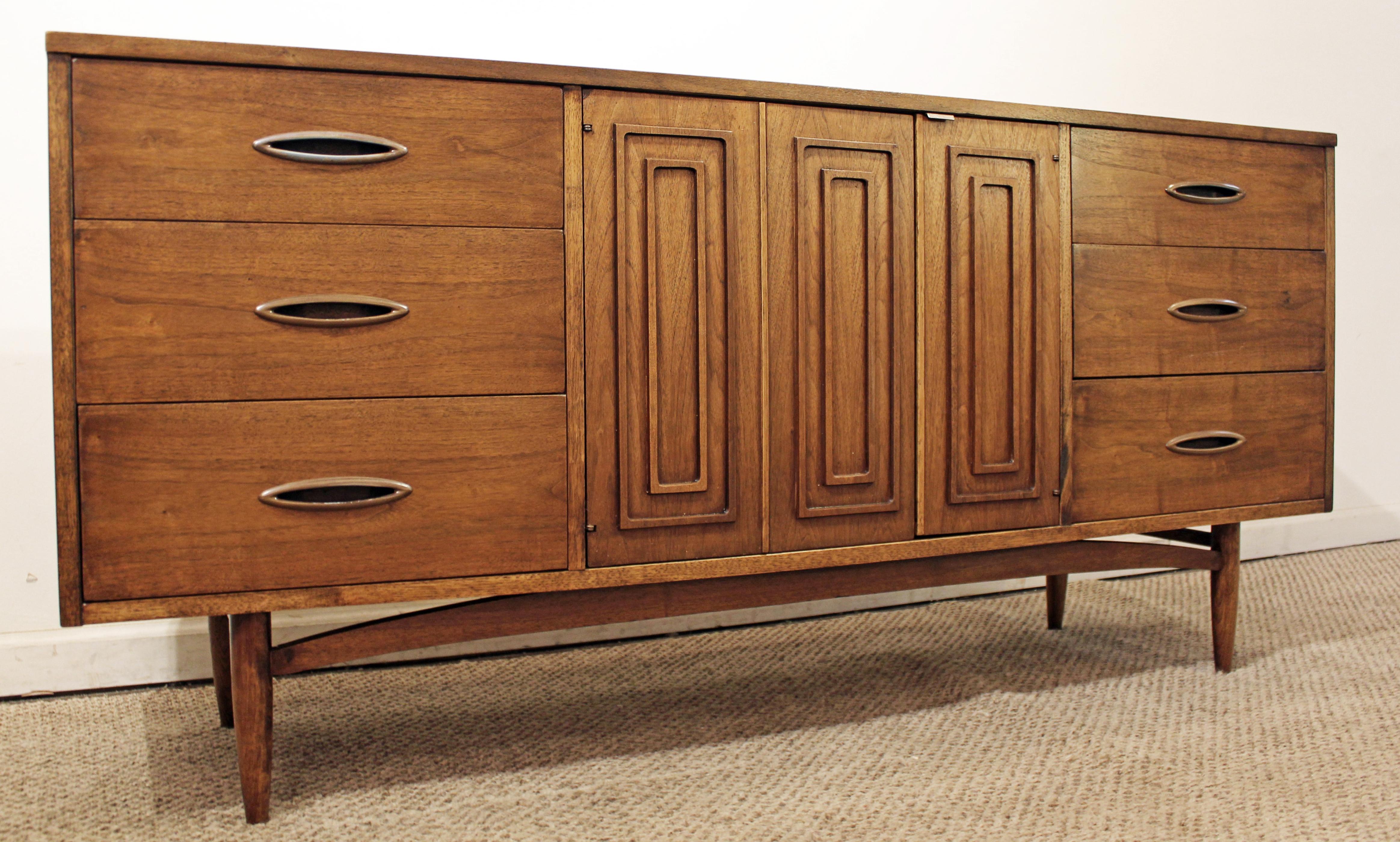 Offered is a mid-century modern credenza. This beautiful 9-drawer walnut credenza was made in 1957 for Broyhill's Sculptra line. It is in excellent condition, recently refinished with minor surface scratches and wear (see pics). It is not signed.