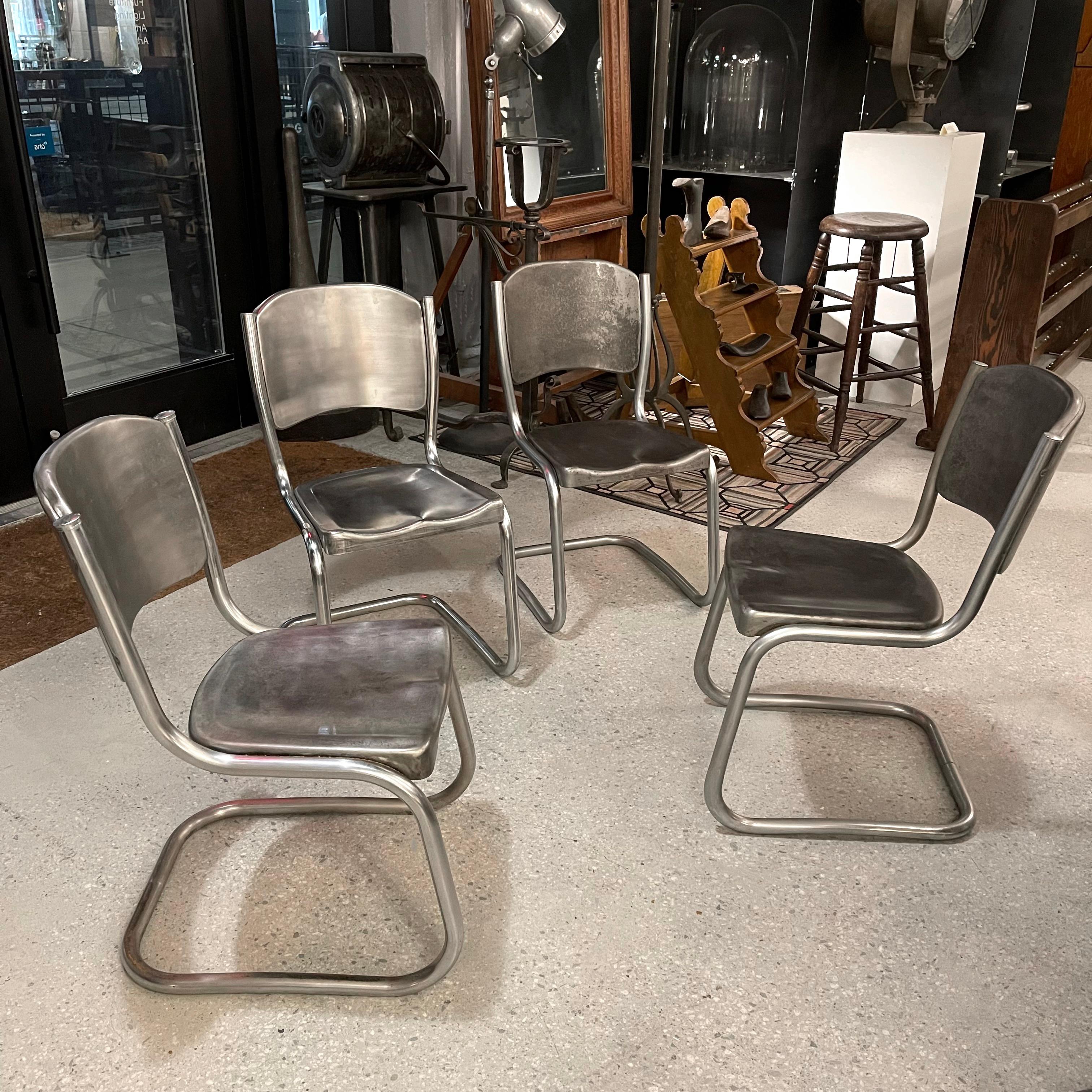 Set of four, mid-century, tubular, brushed steel, dining side chairs with cantilever bases and contoured seats.