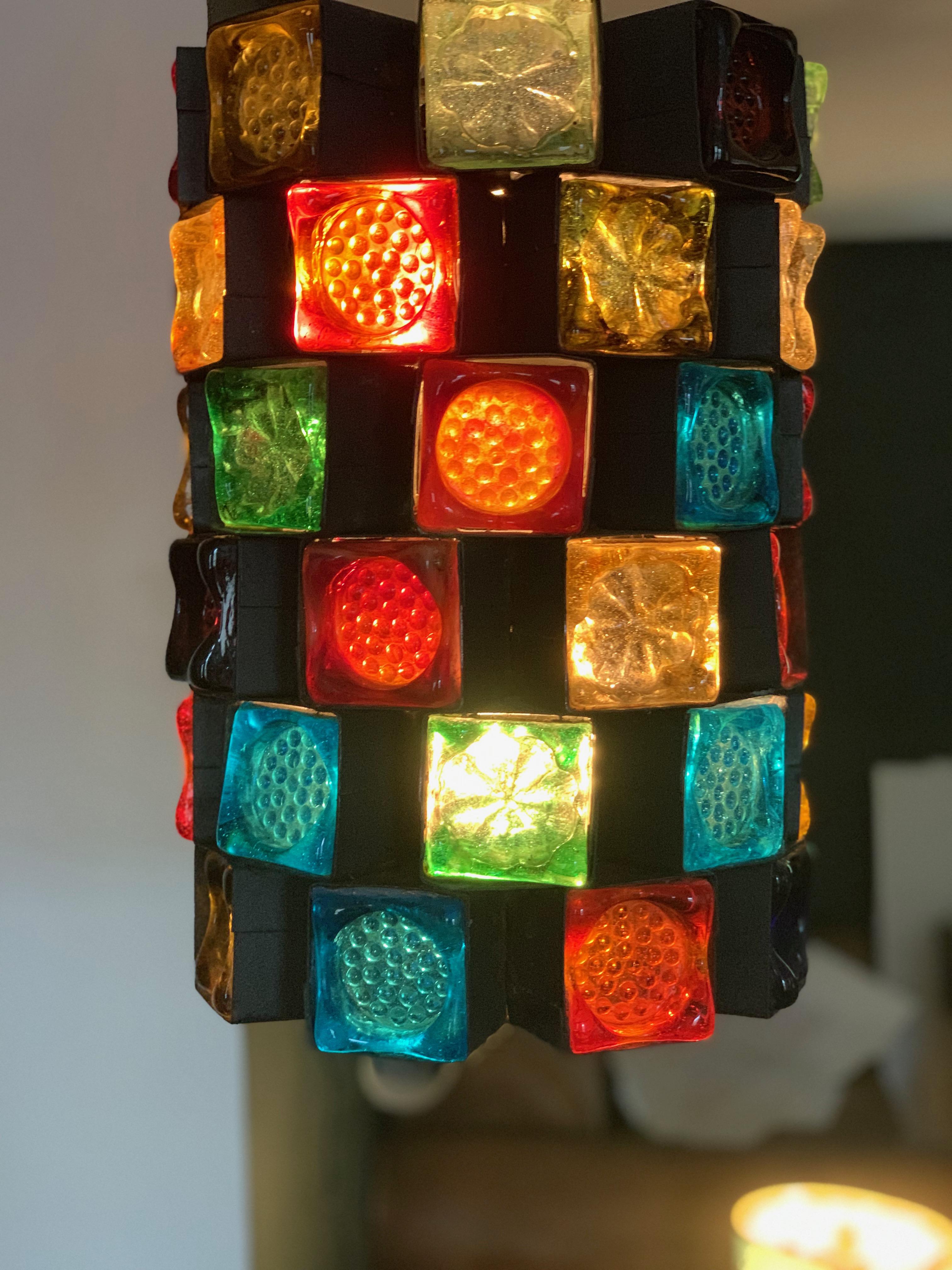 Midcentury Italian Brutalist early Poliarte Forged metal and stained glass pendant light fixture

Gorgeous piece from early in the career of Poli-Arte, hand blown Murano stained glass cubes with uniquely patterned surfaces, each in its own forged