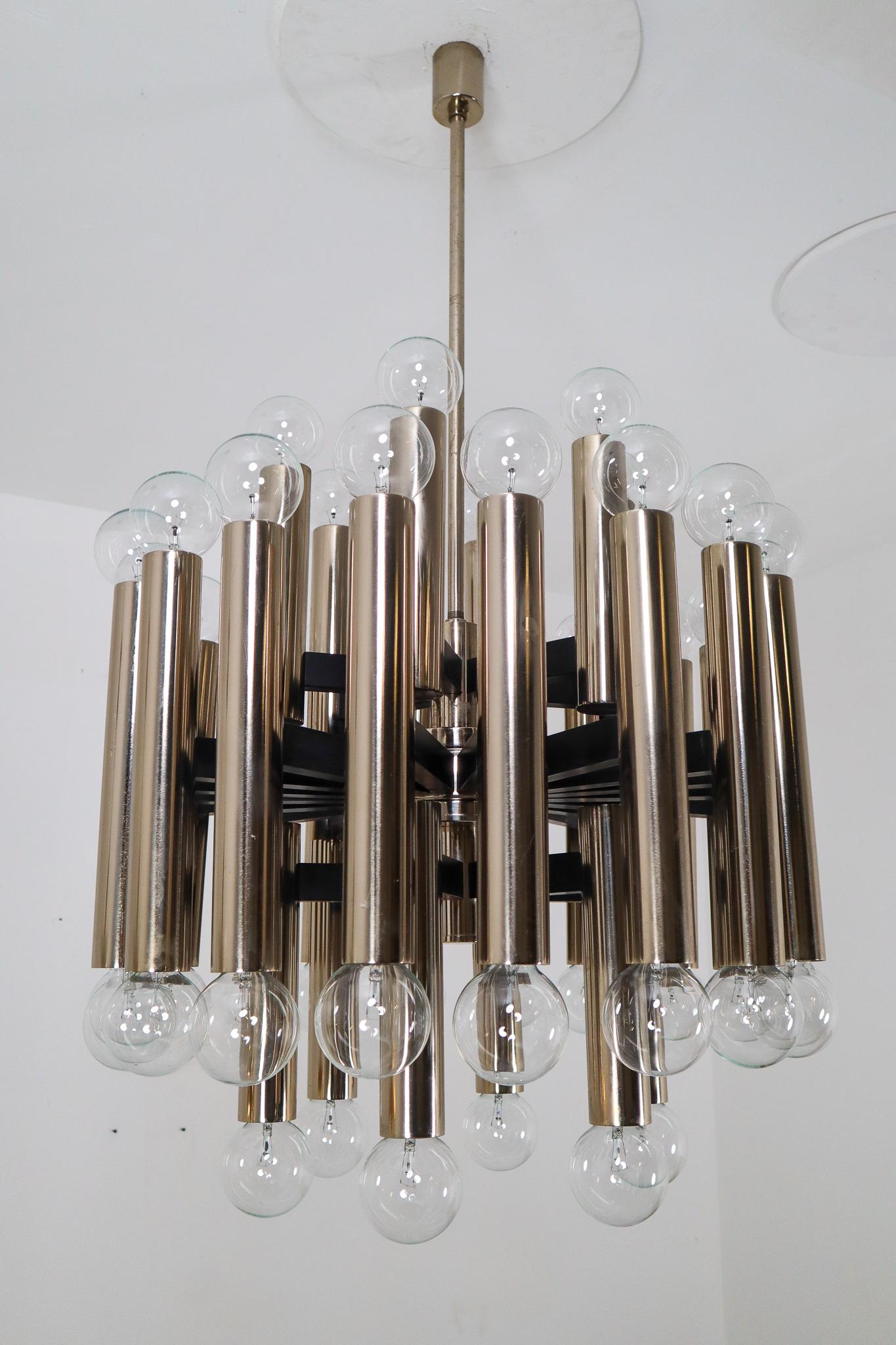 Mid-Century Modernist extreme large chandelier with 48-light bulbs. The fixture is made of metal with a steel-brass patina. Therefore an interesting color is visible on the metal. 48 large light bulbs are placed over four levels. A warm and diffuse