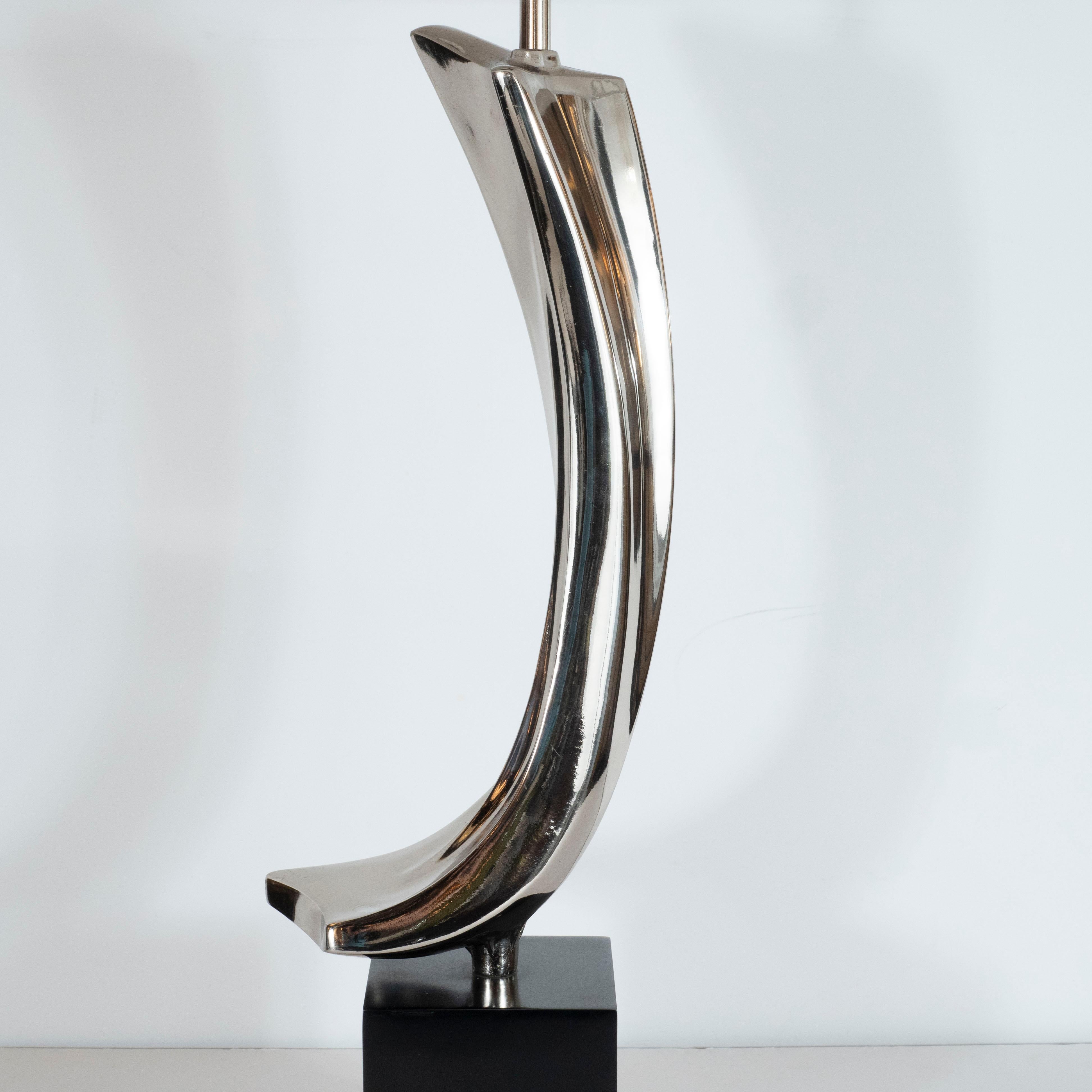This sculptural and dynamic Mid-Century Modern lamp was designed by Harold Weiss and Richard Barr manufactured by the Laurel Lamp Company in the United States, circa 1960. Forged in lustrous chrome- offering the appearance of quick silver- it