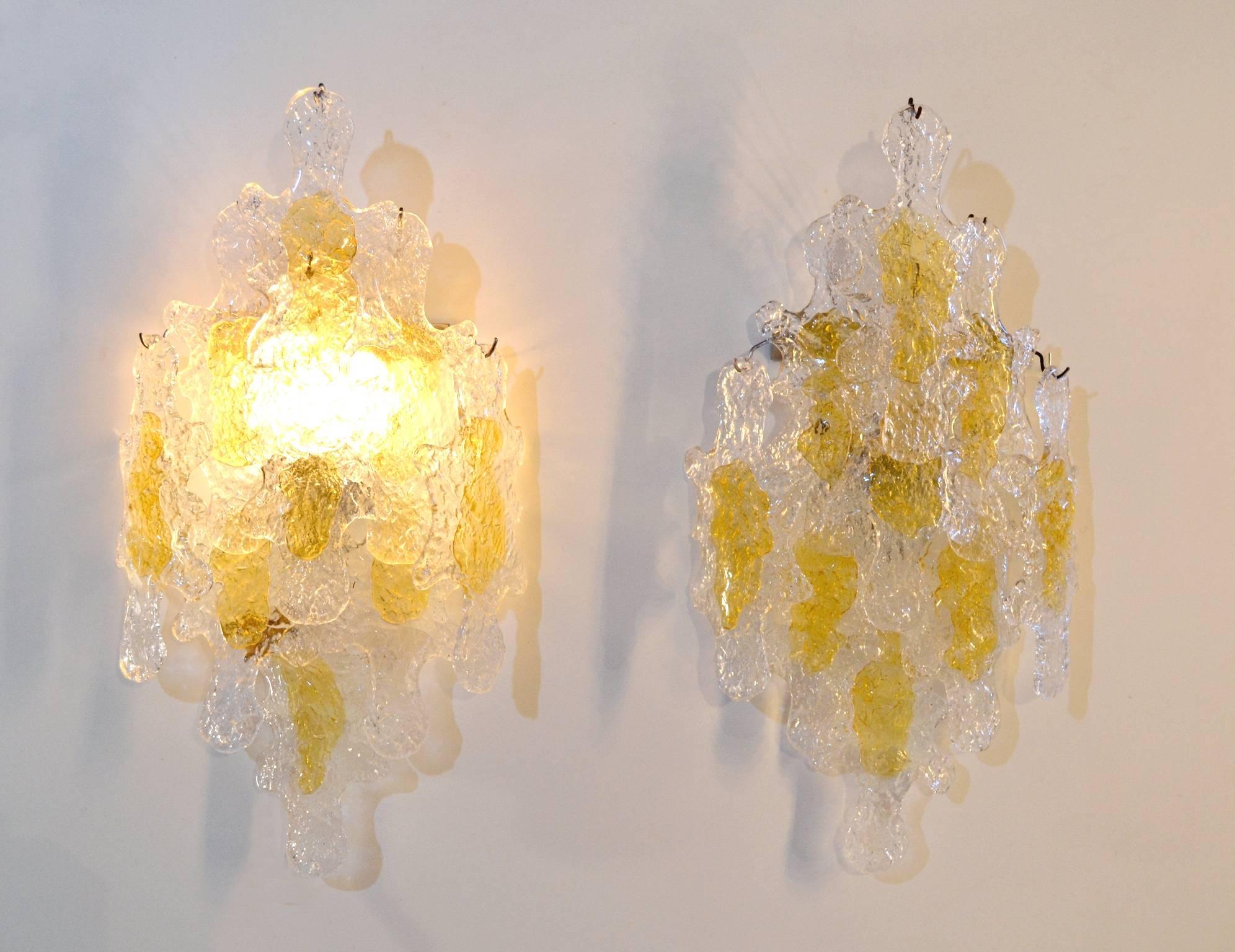Pair of extra-large wall sconces by Mazzega, Italy. Each sconce contains large pieces of clear and yellow glass. Excellent condition and delivered with extra discs. These wall sconces comes from old stock and has never been in use.