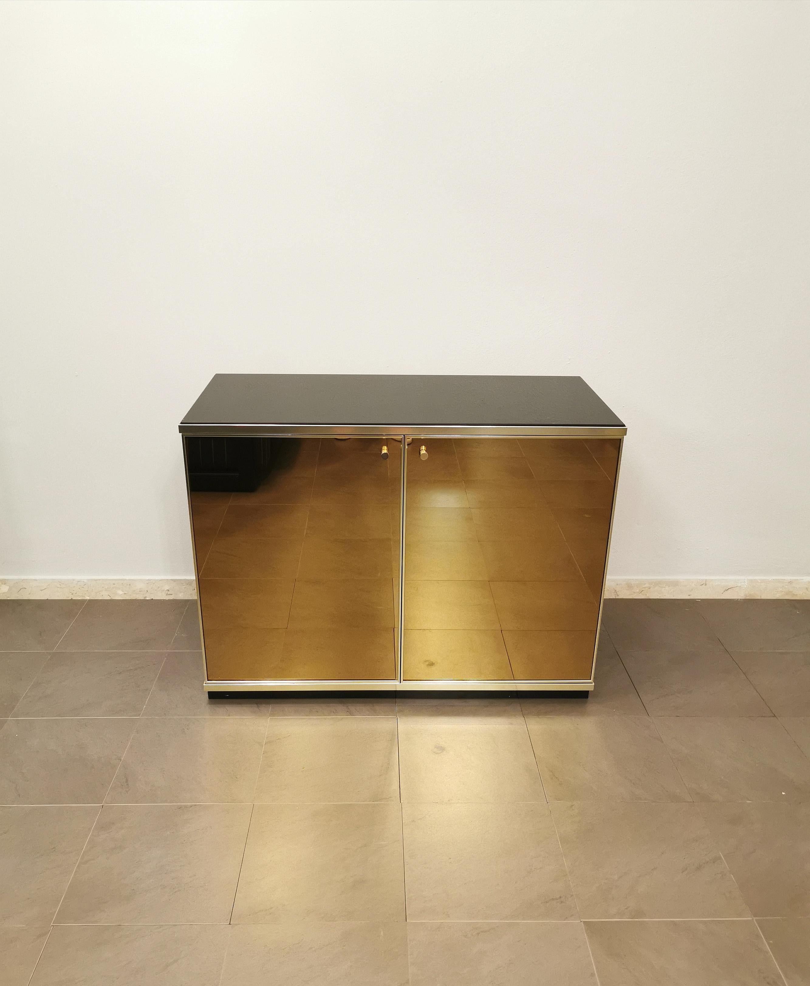 Elegant buffet / sideboard designed by the Italian designer Renato Zevi in the 70s. The buffet has a black lacquered wooden structure, a dark glass top, 2 bronze mirrored glass doors with sand-colored suede inside and 1 wooden shelf. Finishes in