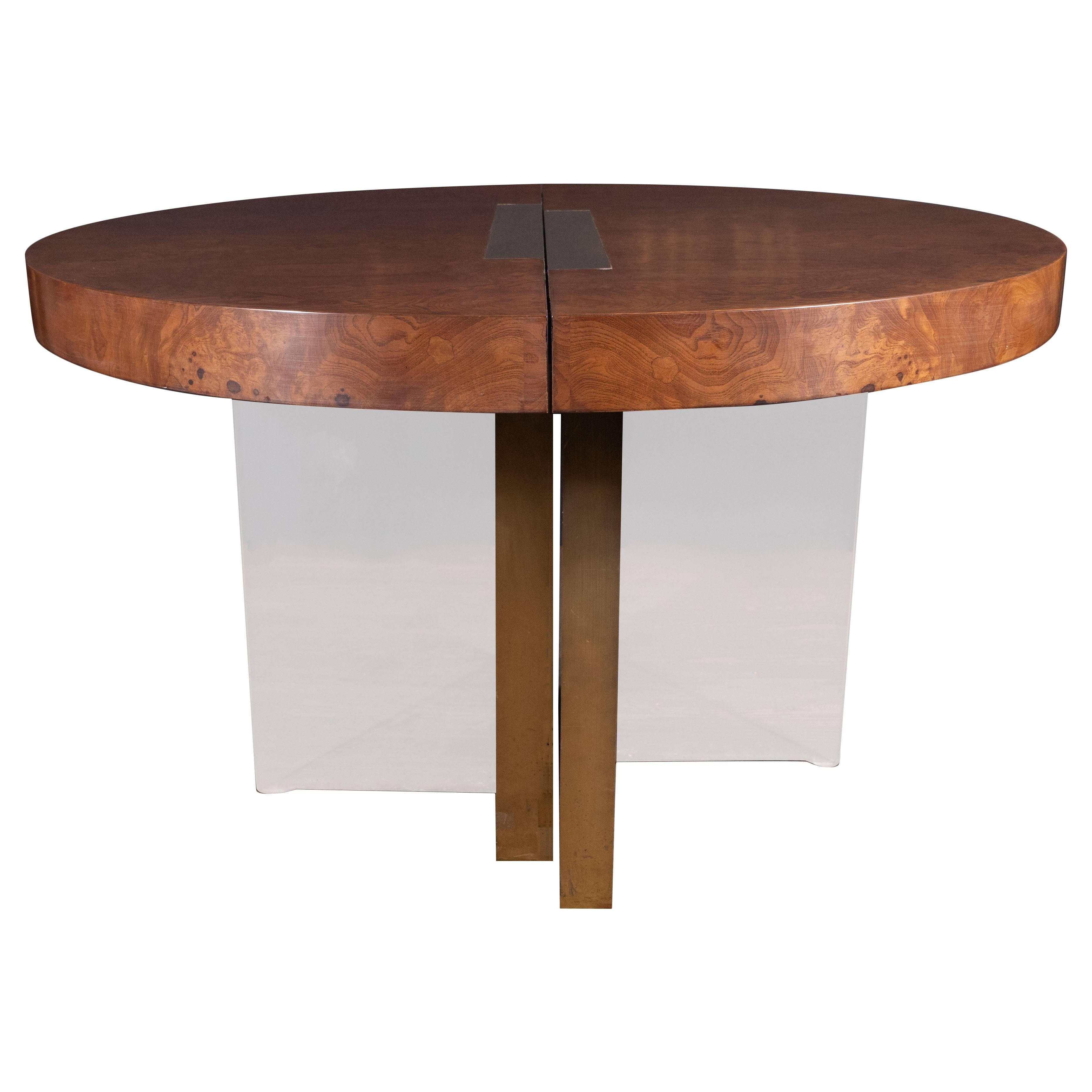 This stunning dining/center table was realized by the fabled American designer, Vladimir Kagan and handcrafted in the United States, circa 1976. It offers a circular burled olive ash top with two inlaid offset rectangular polished brass inserts,