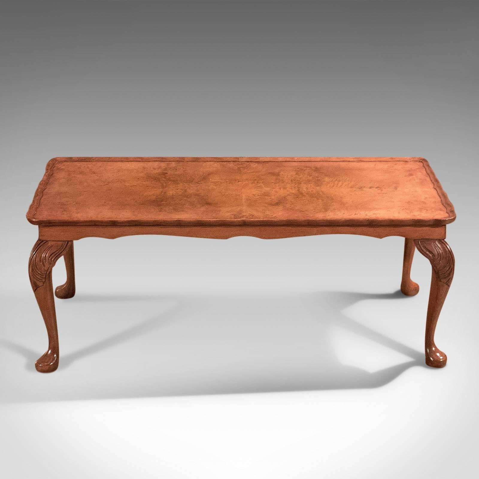 This is a good quality midcentury coffee table in the high Victorian taste.

An attractive narrow coffee table presented in excellent condition
Displaying quality burr walnut top, classically 'bookmatched'
Raised on pad feet to elegant cabriole