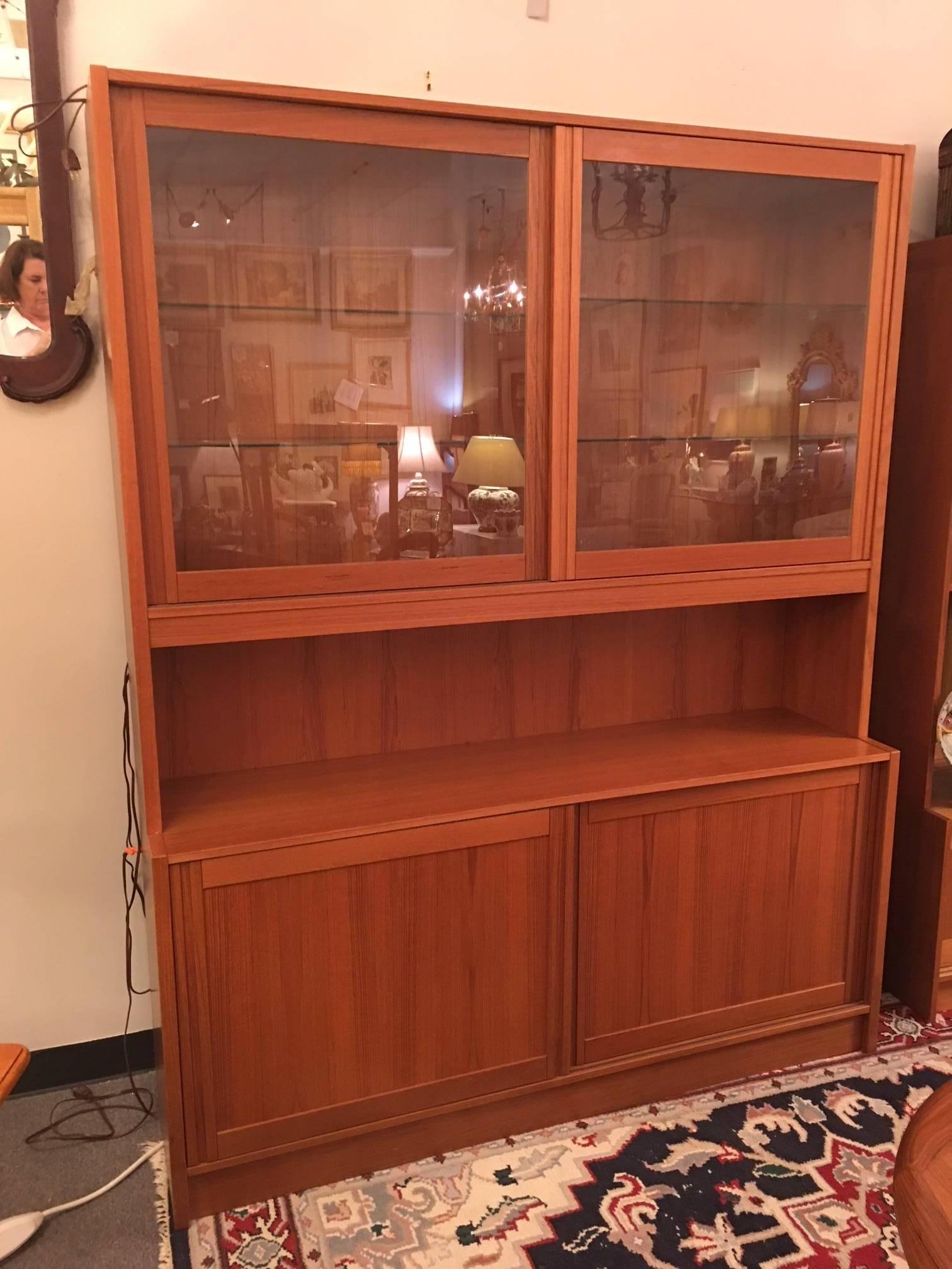 This sweet MCM cabinet can serve as a china cabinet, a library cabinet, a curio cabinet or whatever other use you find for it. It is in excellent condition. Sliding doors, interior shelves, interior lighting. The lighting cord needs to be replaced.