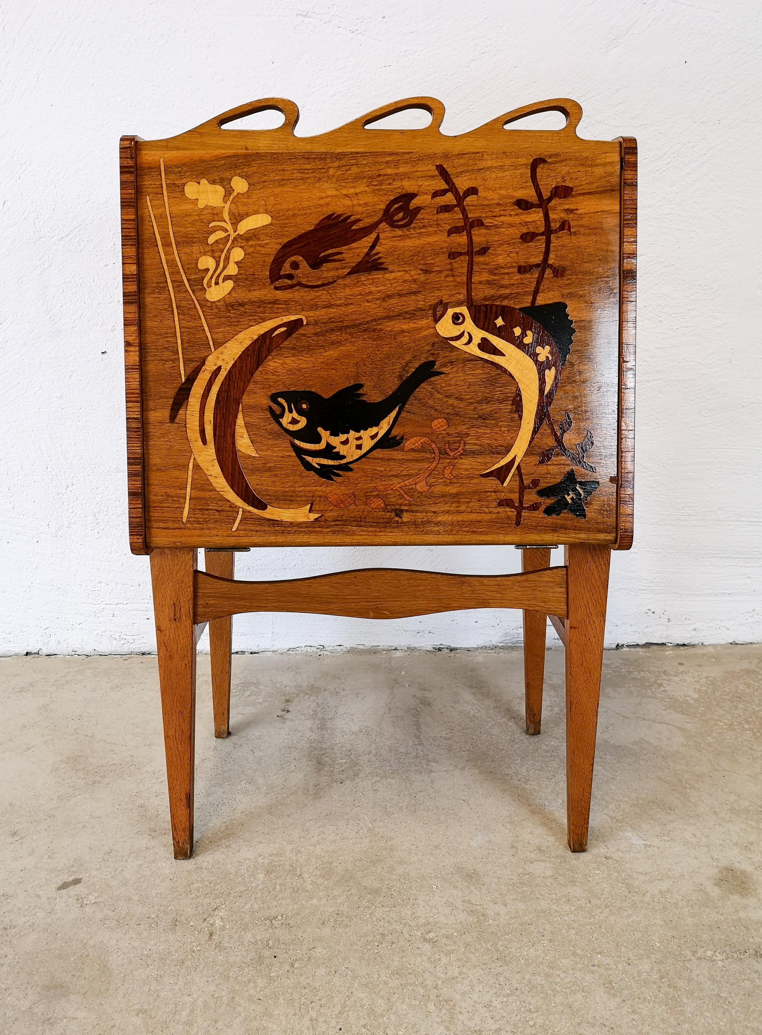 This cabinet has features that links it to famous Mjölby Intarsia. They were famous to make inlays of wood to give cabinets etc. that exclusive look.
The cabinet itself has inlays of fishes and gives the owner a possibility to open and store for