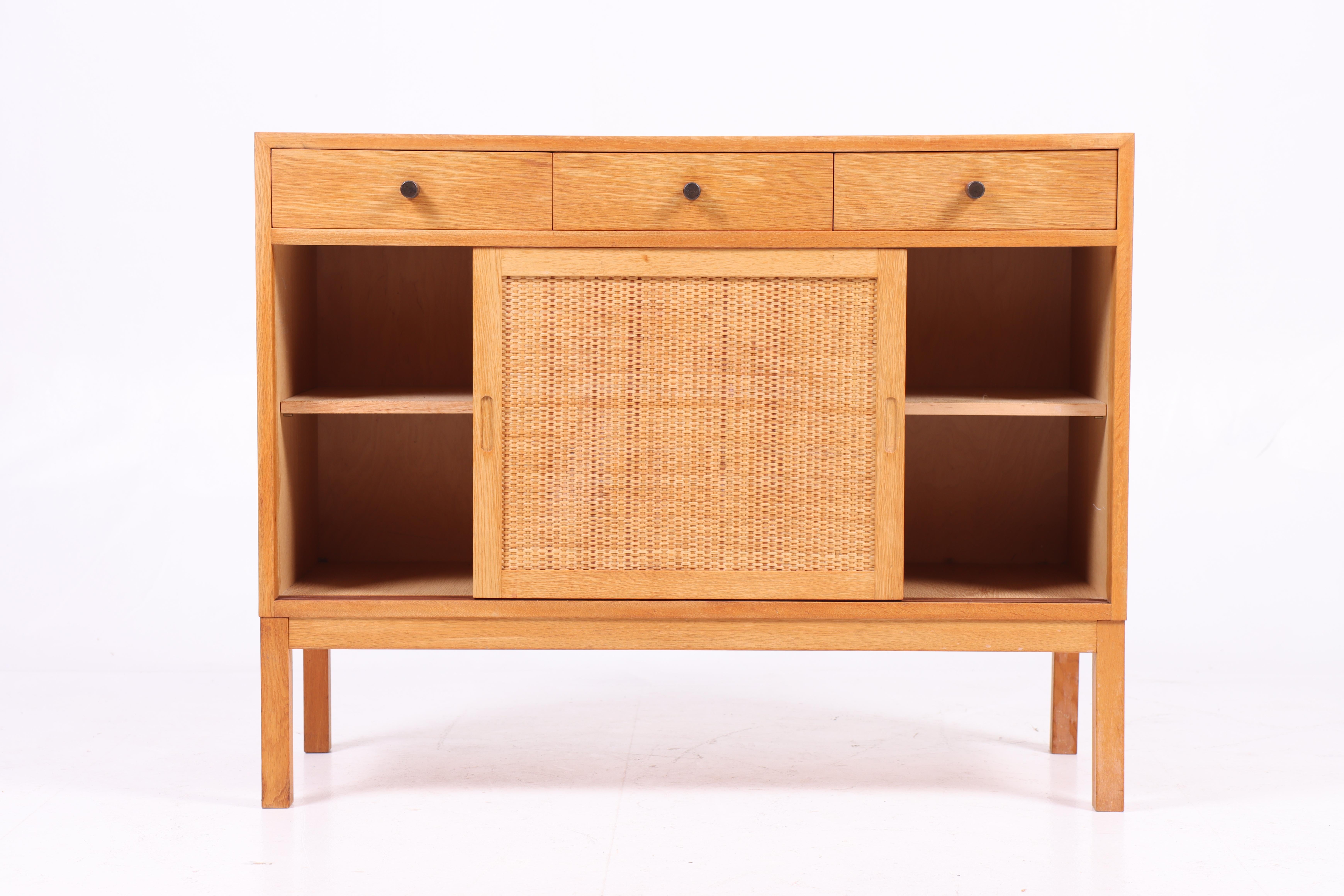 Cabinet with cane door in wax finished Scandinavian oak. Designed and made in Sweden. Great original condition.
 