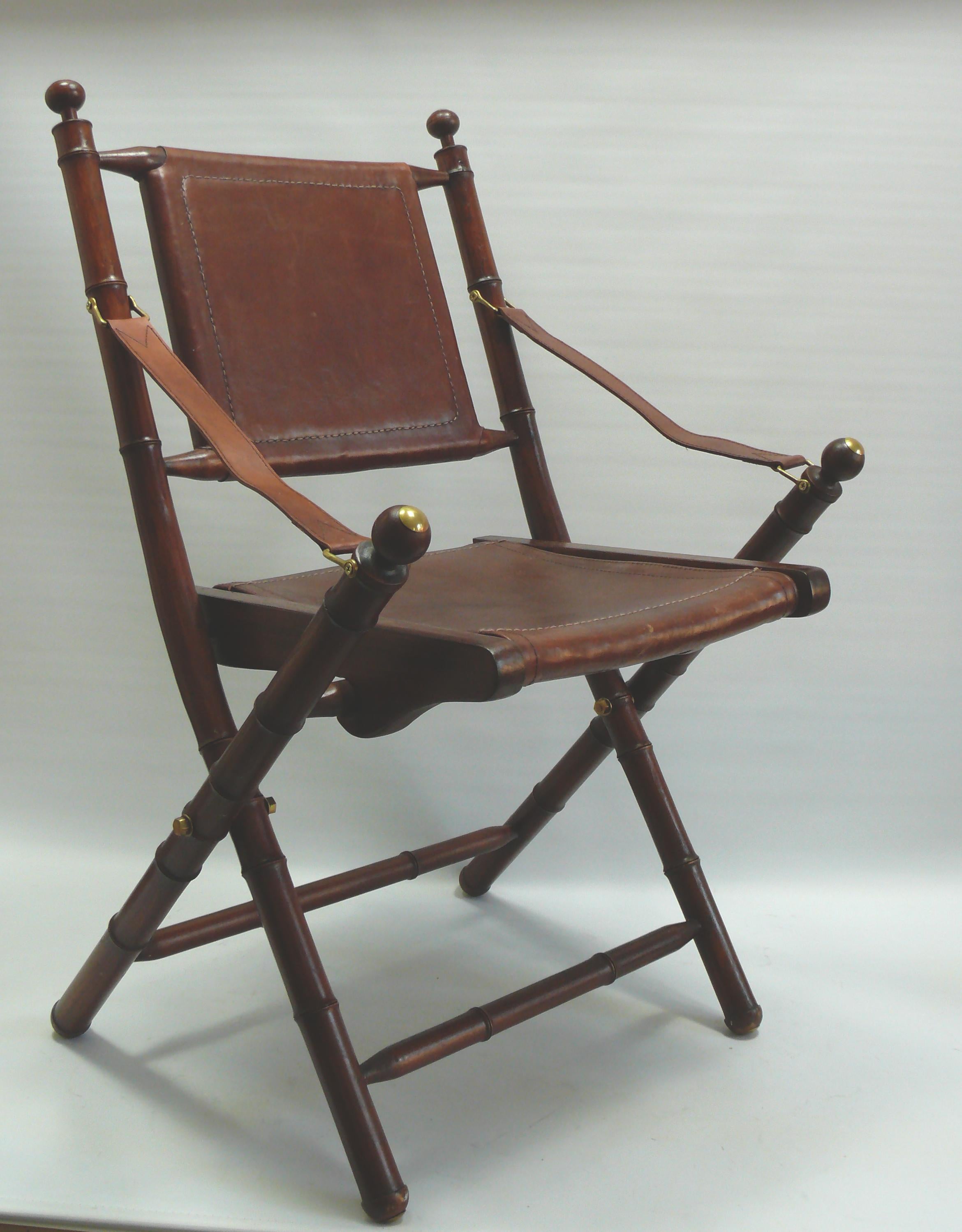 Silla plegable de campaña / Sillas de oficial de teca con asientos de cuero resistente; estilo bambú/colonial - probablemente de mediados de siglo. Fabricado por Eichholtz en Holanda.

Sillas muy bien conservadas de teca barnizada con asientos,