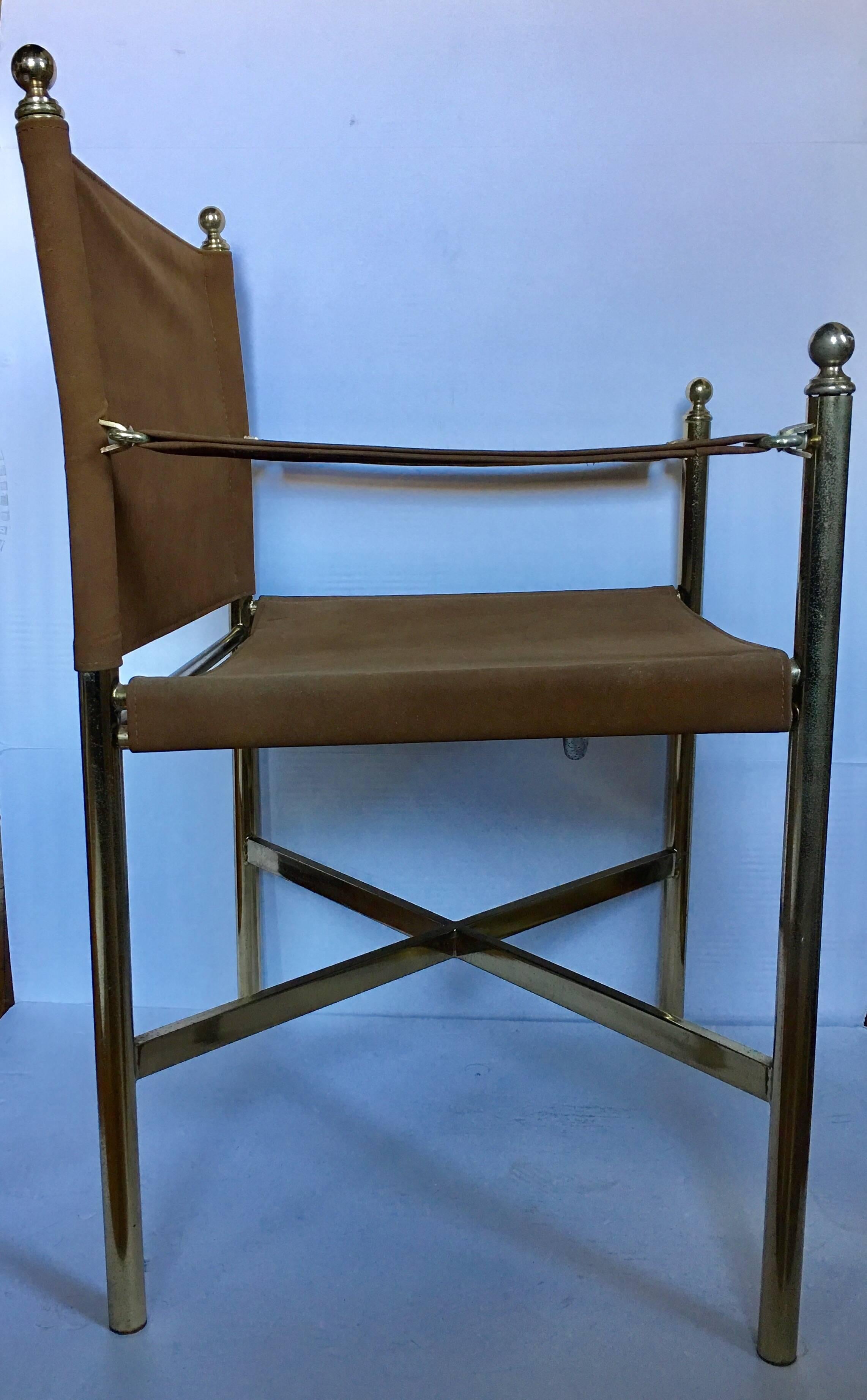 Mid Century Campaign style accent armchairs featuring brass-plated metal frames with decorative buckles and finials. Original brown tone upholstery. Perfect for occasional seating or for desk seating.  Back and seat could easily be reupholstered by