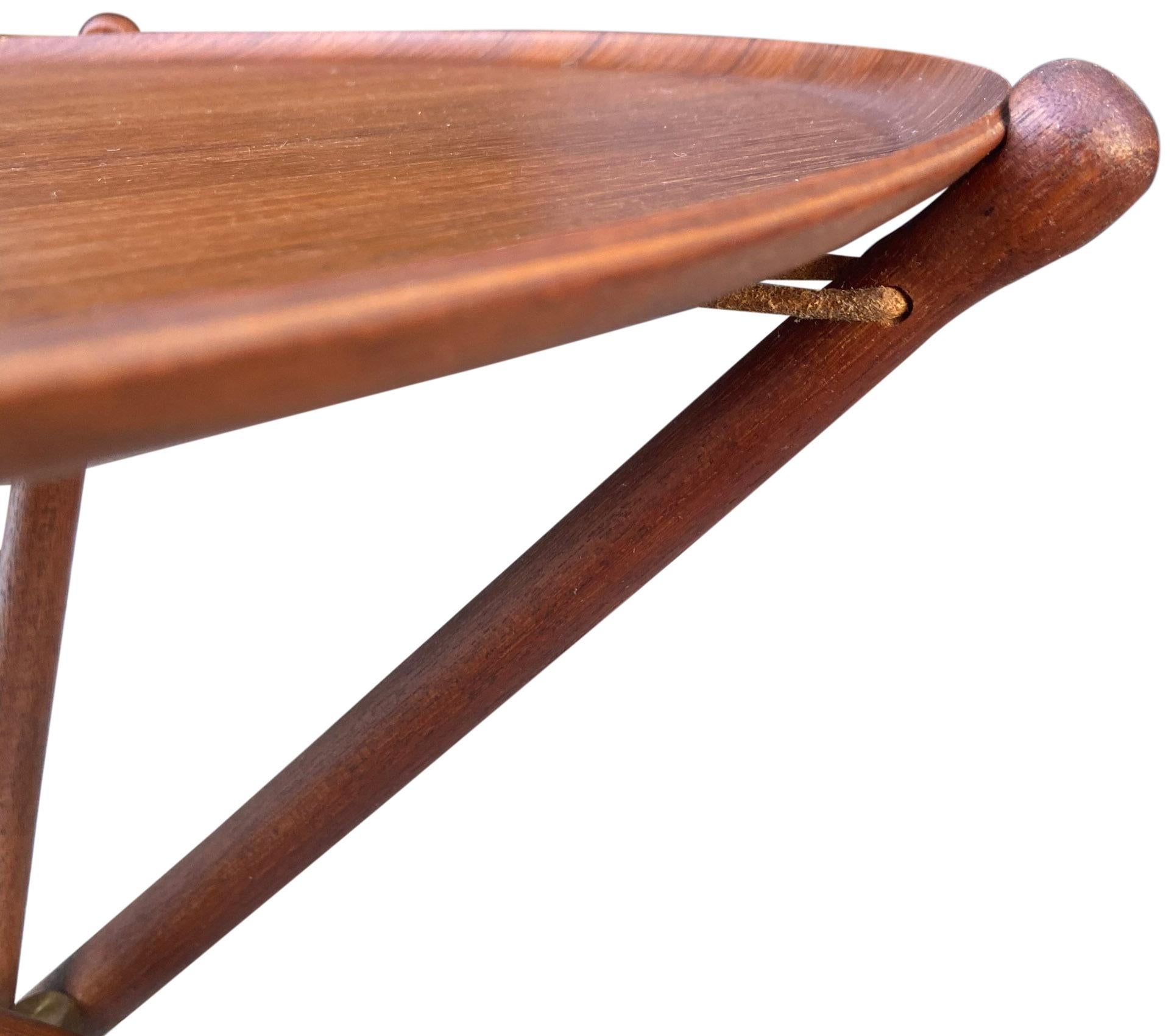 Nous vous proposons ces tables-plateaux scandinaves réalisées par Nils Trautner pour Aris. Ces merveilleuses tables tripodes utilisent un cordon de cuir épais et des accessoires en laiton pour créer une tension qui maintient solidement le plateau en