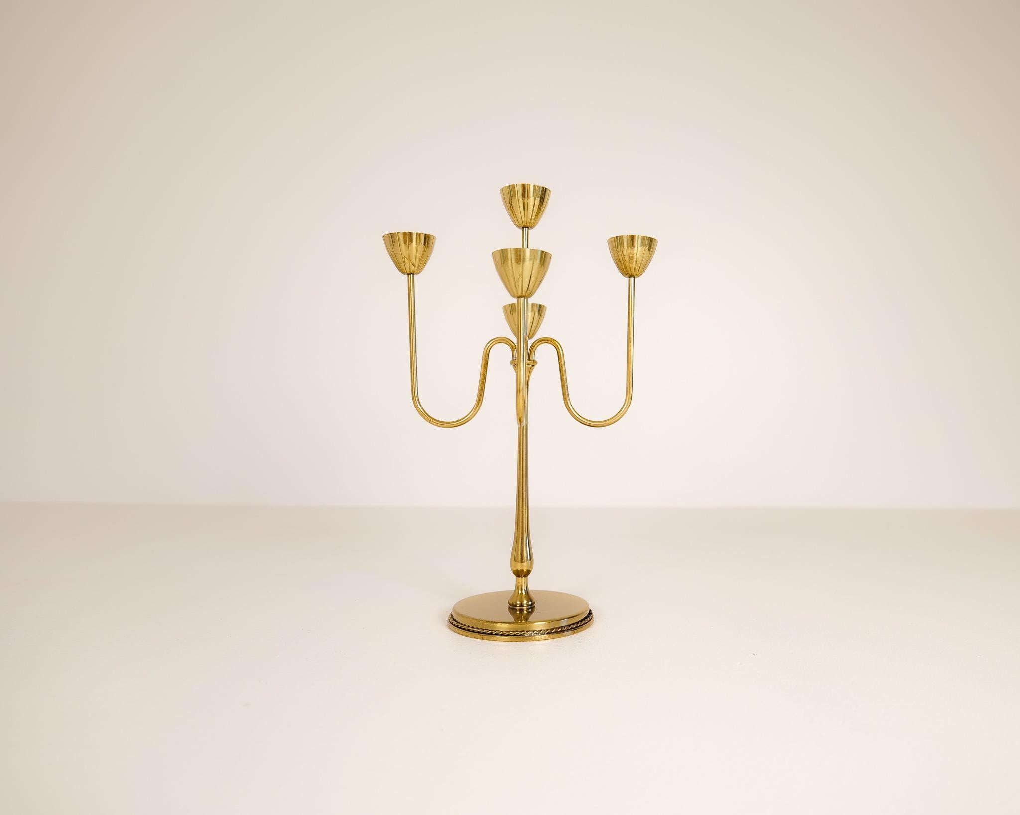 This brass candelabra was made in 1960s at Ystad Metall in Sweden. Designed by Gunnar Ander. Nice, lined brass with holders for small candlesticks.

Good condition with wear of age. 

Dimensions: Height: 12.41 in. (32 cm) Width: 8.08 in. (21 cm)