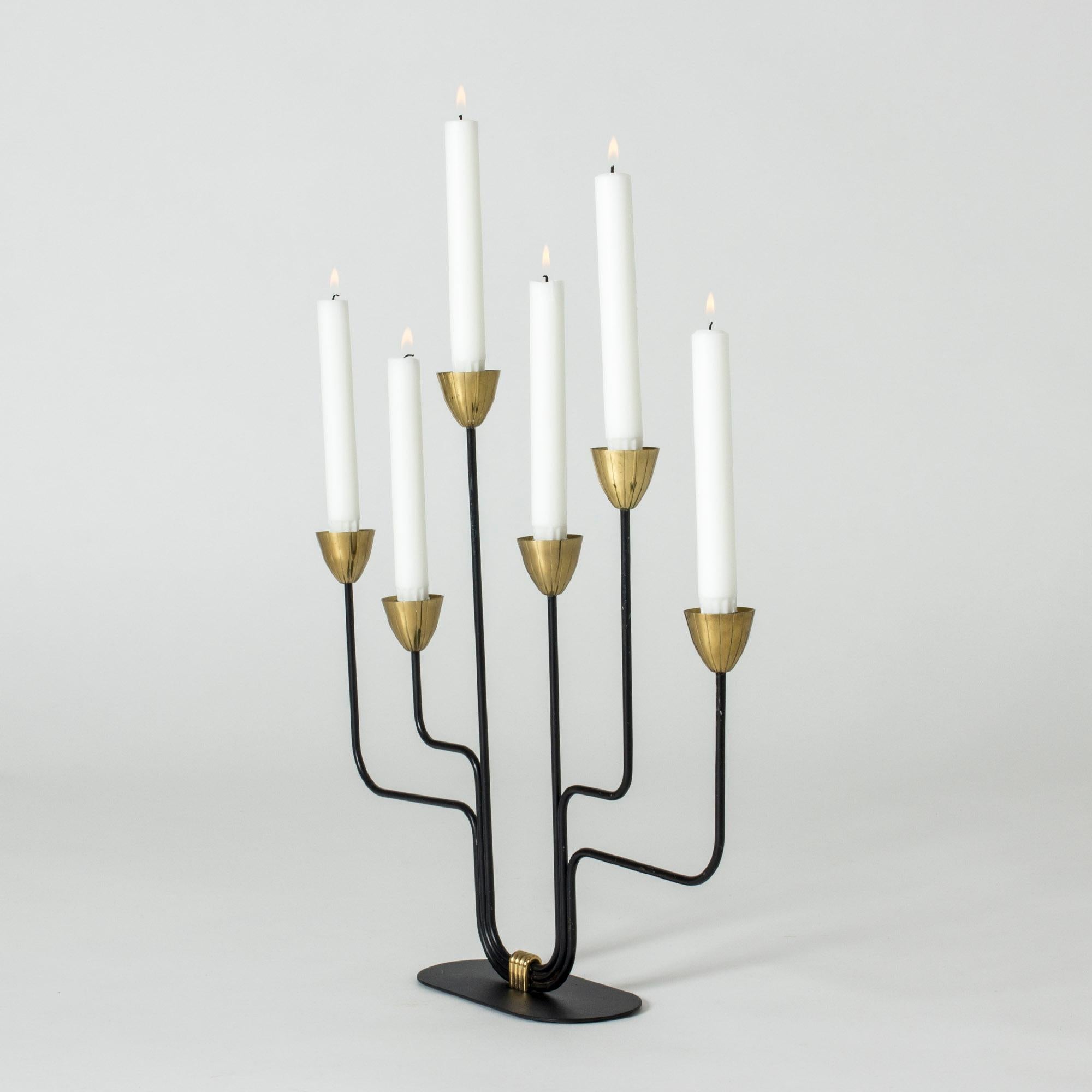Striking lacquered metal and brass candlestick with six arms by Gunnar Ander. Great play between the sleek thin black frame and the warm brass.
