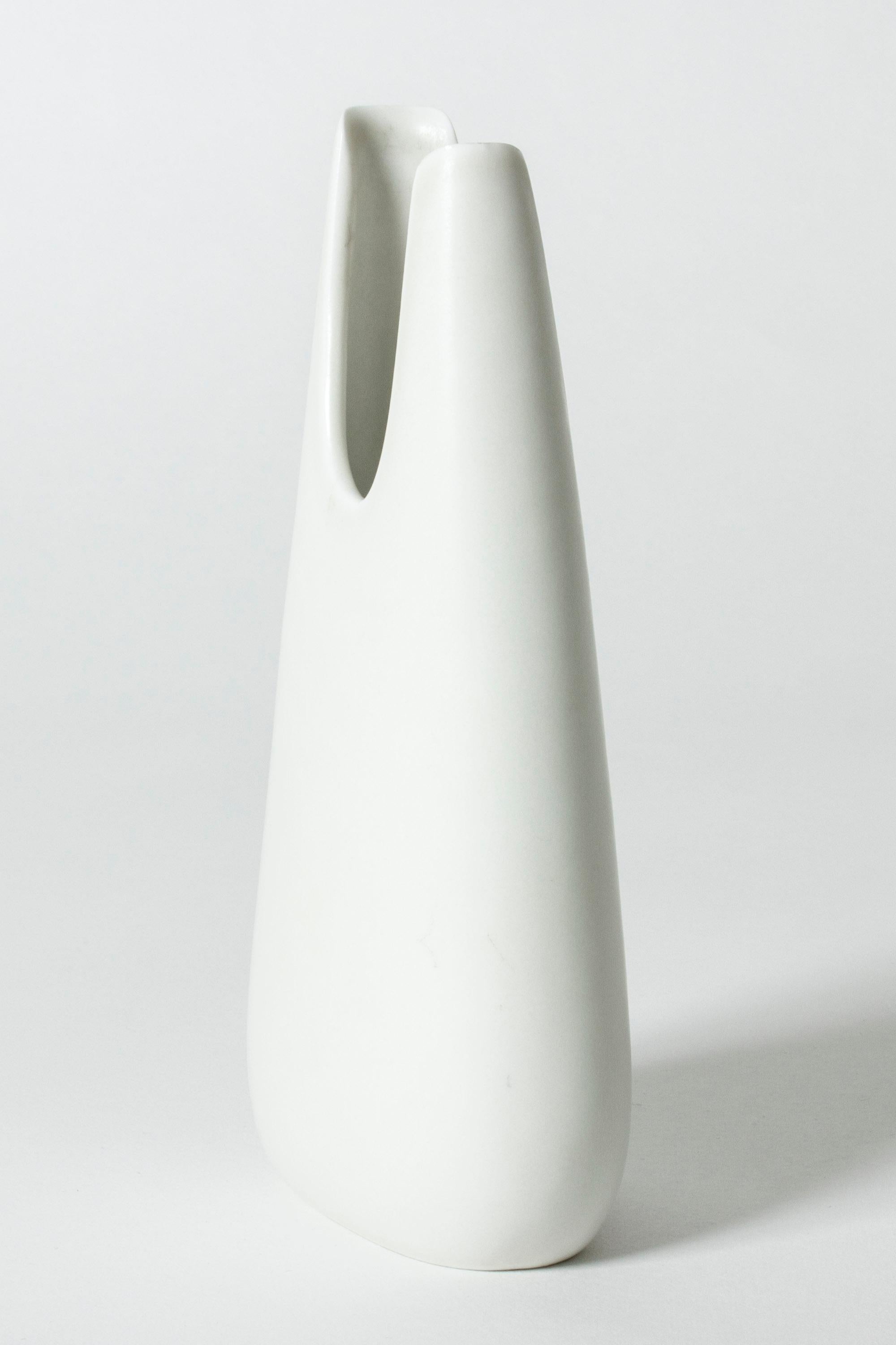 Cool “Caolina” stoneware vase by Gunnar Nylund, in a smooth, asymmetric form. Clean design with crisp white glaze.

Gunnar Nylund was one of the most influential ceramicists and designers of the Swedish mid-century period. He was Rörstrand’s
