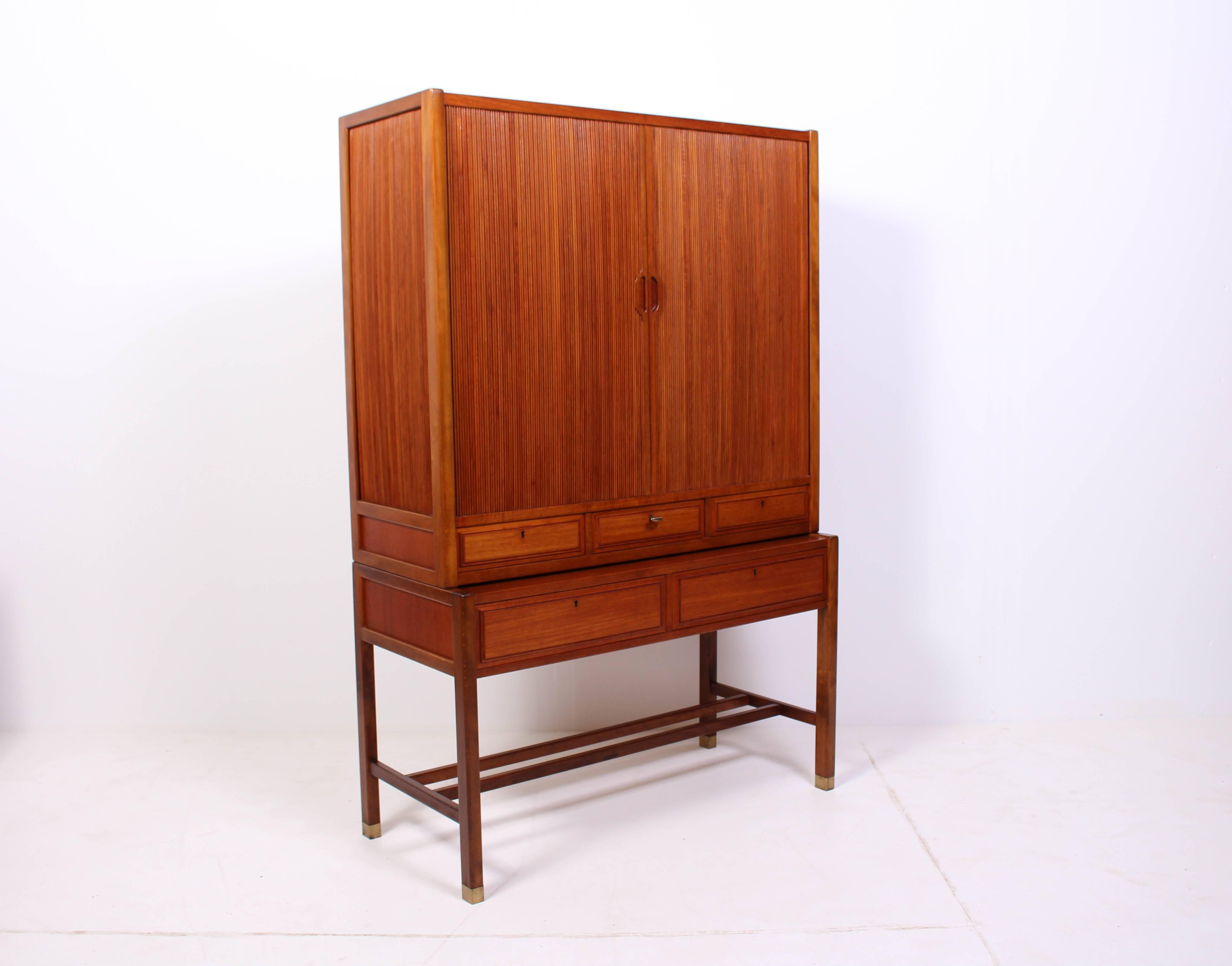 Midcentury Swedish cabinet by Carl-Axel Acking for Bodafors. The cabinet has many details such as tambour doors and brass feet. It is in very good vintage condition with minor signs of usage.
  
     