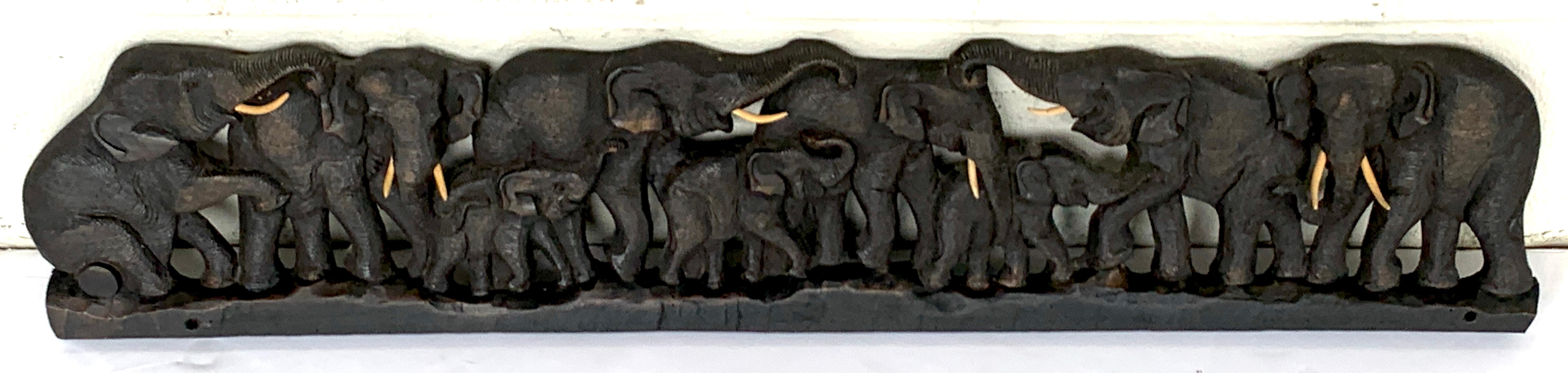 Midcentury carved teak wood 9 elephant panel, realistically carved with wood polychromed wood tusks, and mounting holes at base
Measures: 38 x 9 x 1.