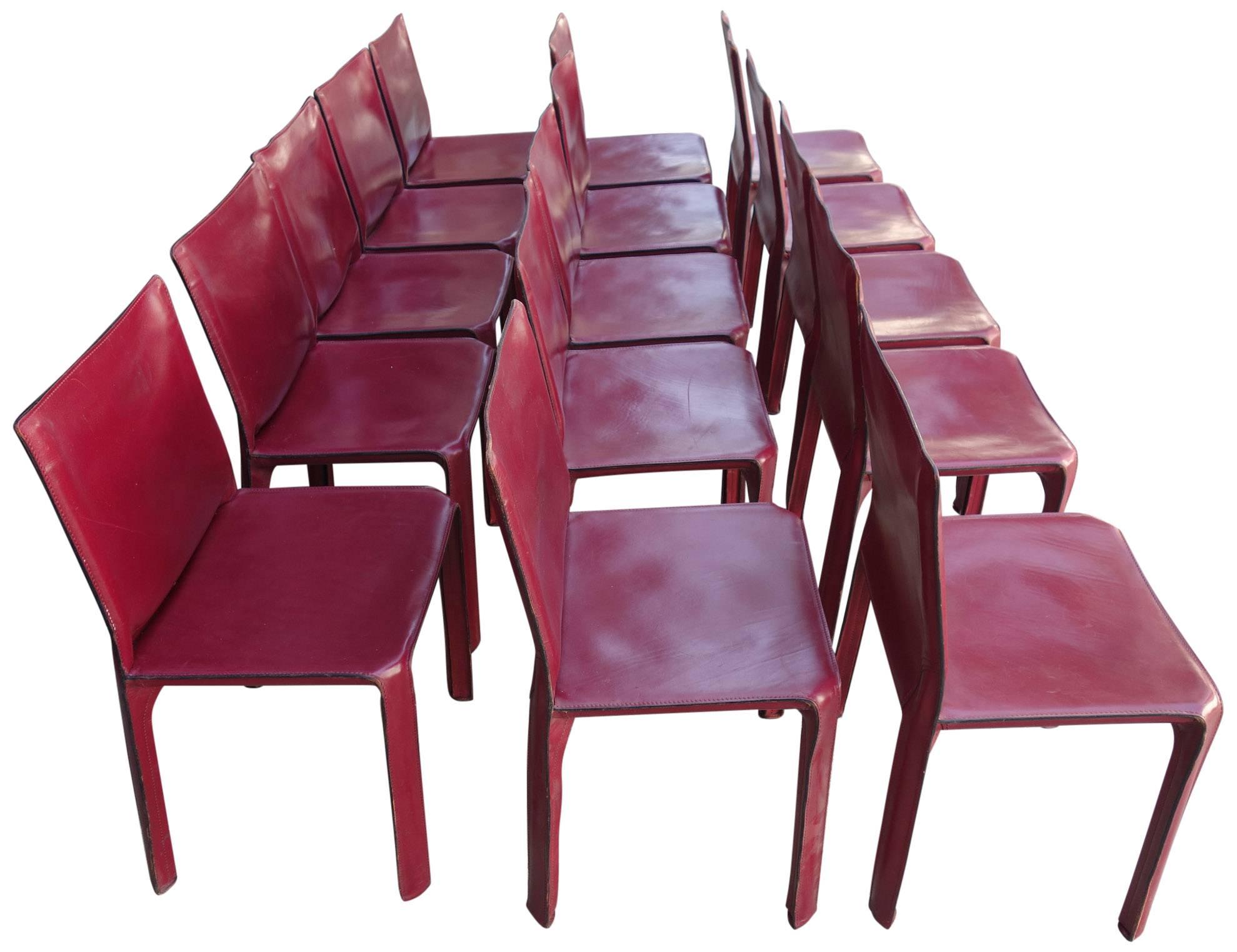 Wonderful set of 15 midcentury CAB dining chairs in red saddle leather wrapped around a steel frame. All display constant age appropriate wear and patina. This design is part of the permanent collection at the MoMA.

Model 412.