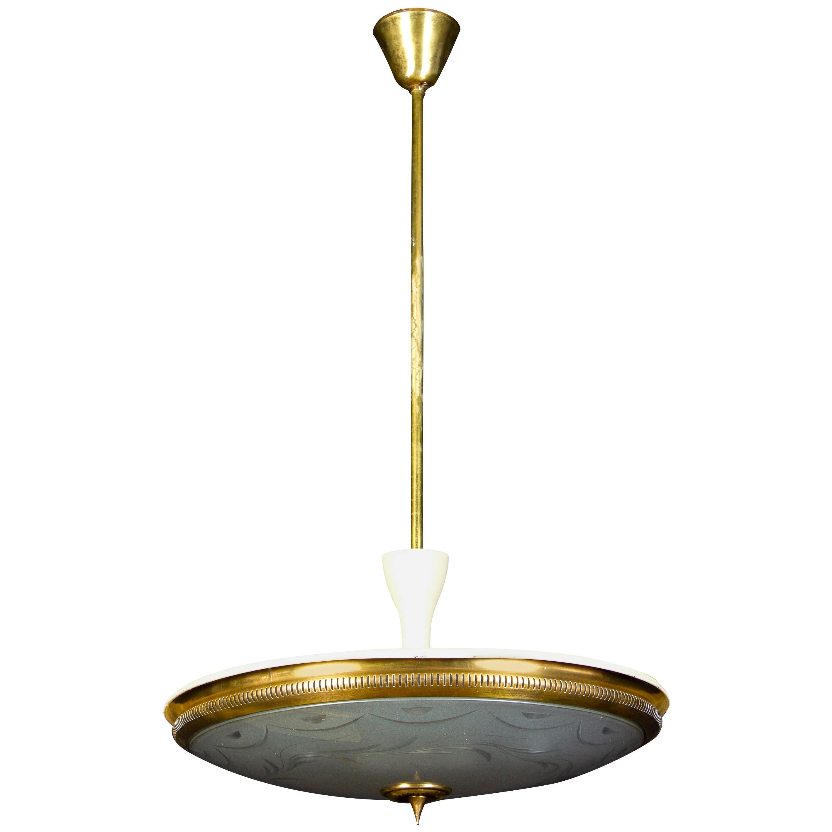 Rare and early pendant by Luigi Brusotti with a precious engravings on the crystal etched acid disc, supported by a partial ivory lacquered brass frame.
Brass finial, stem and ceiling cup.
Four Edison sized sockets.

 