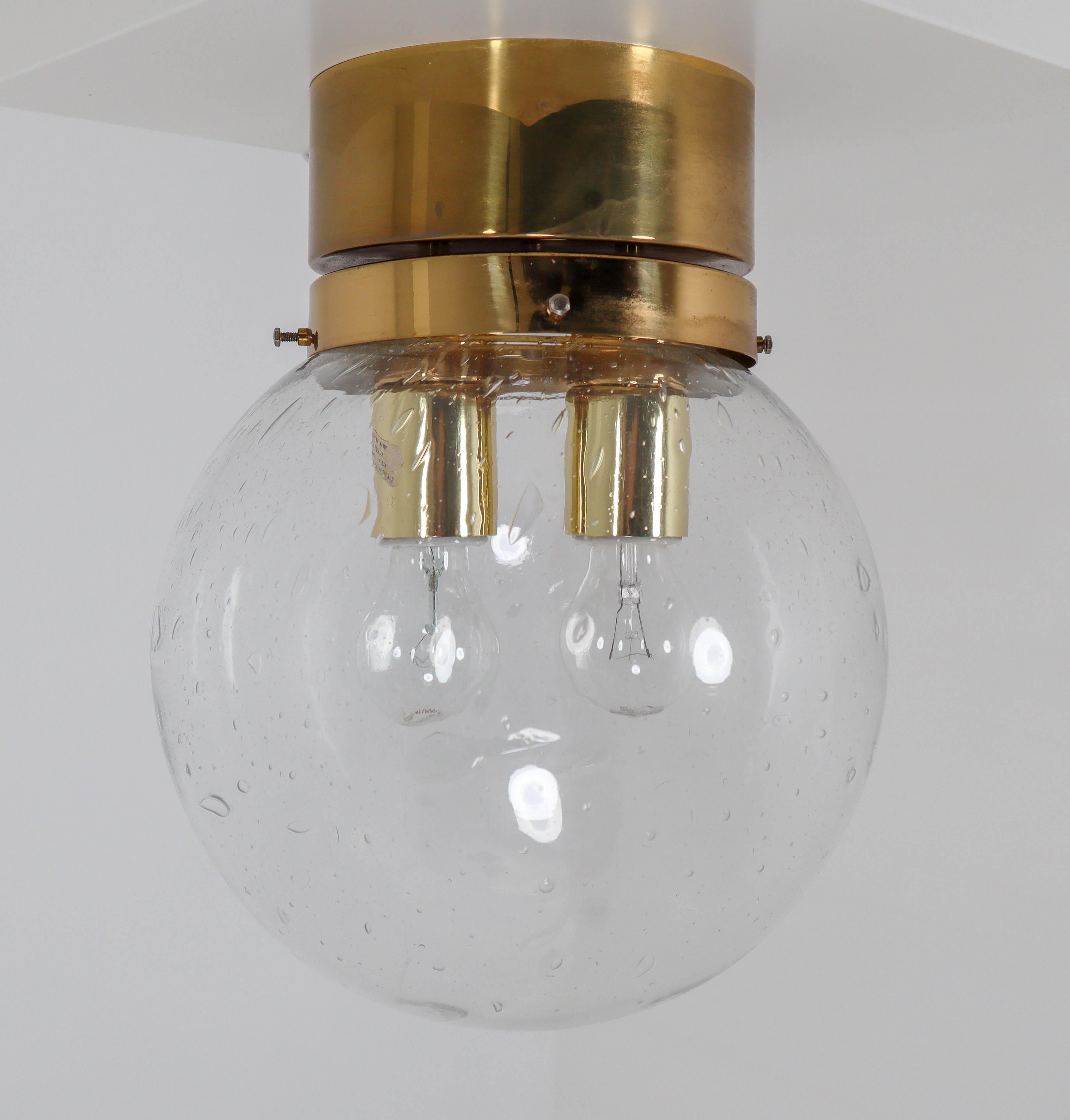 Midcentury hotel ceiling or floor lights with brass frame and large hand blown glass. The lights are beautifully thanks to the hand blown glass. The pleasant light it spreads is very atmospheric, these lights will contribute to a luxurious character