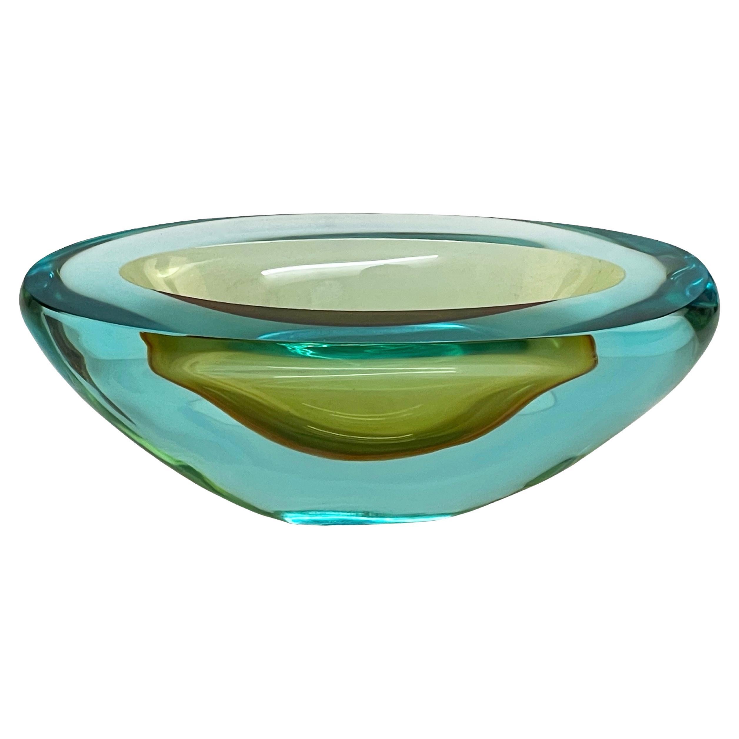 Stunning midcentury aquamarine and amber Murano Glass Bowl. This fantastic piece was designed in Italy during the 1960s and it is attributed to Cenedese.

This big bowl weights 2.4 kilograms, is unique as the glass colour is cangiant: from the