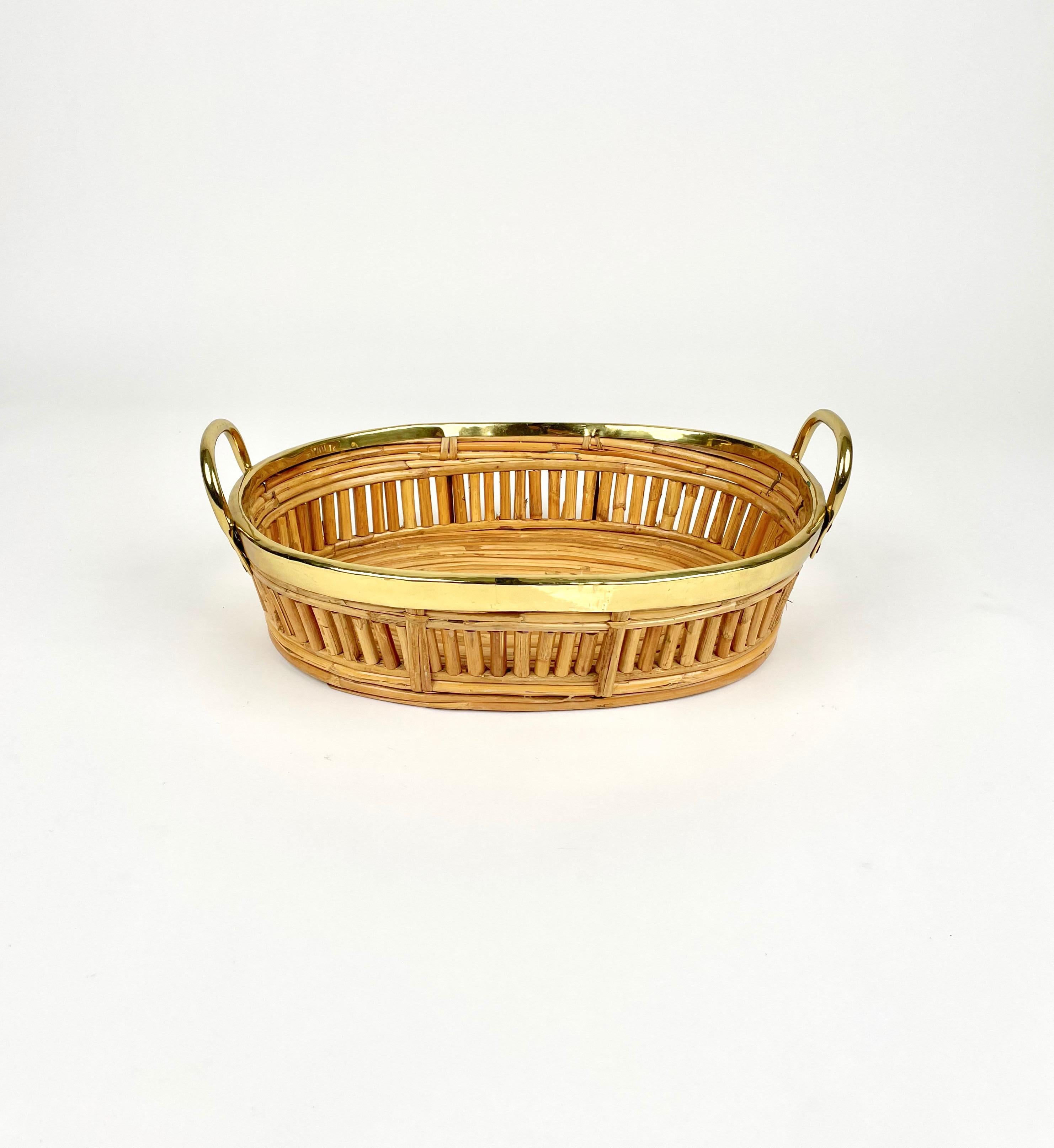 Cesta ovalada para centro de mesa, de ratán, con asas y bordes de latón. 

Fabricado en Italia en los años 70.