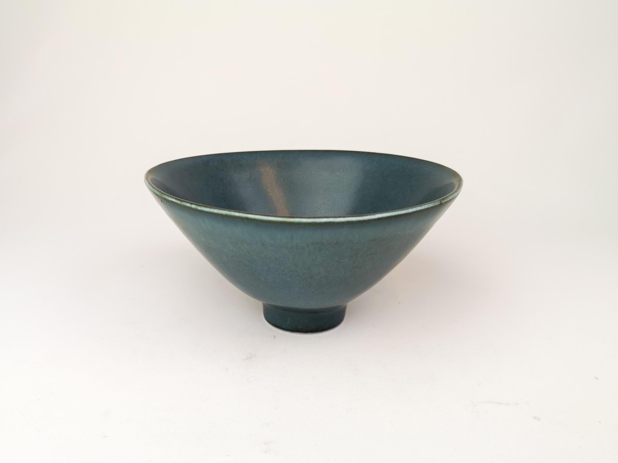 Wonderful bowl on a small foot. Manufactured in the 1950s at Rörstrand, designed by Carl Harry Stålhane. 
The bowl has a wonderful glaze and it lifts the shape of the bowl to a wonderful object. 

Good condition:

Measures: H 9 cm, D 19 cm.
 