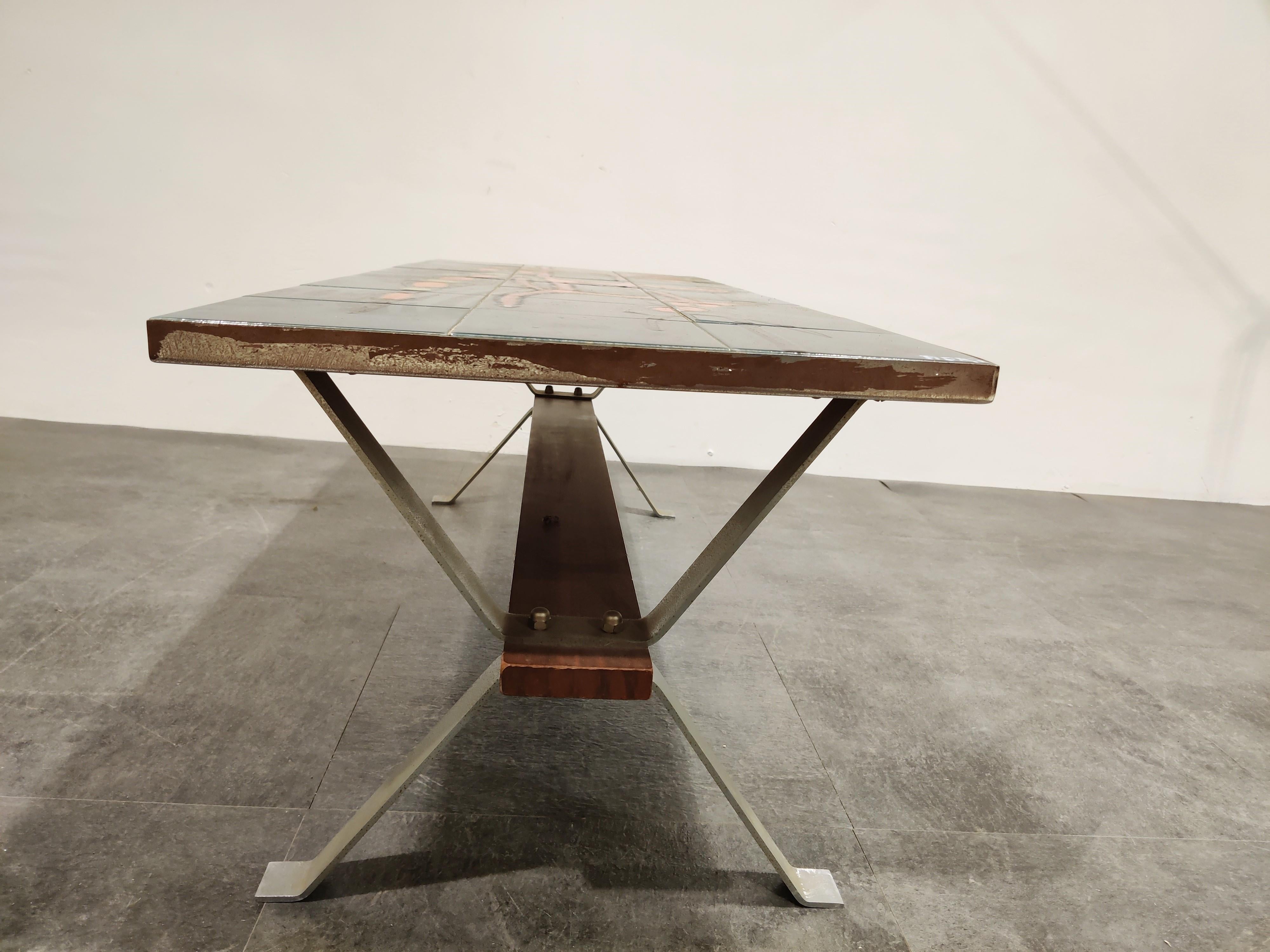 Stricking midcentury coffee table with a ceramic tiled top and a teak/chrome frame.

The table is signed by Adri.

Attractive colors and modernist design.

Untouched condition with rust marks on the side of the coffee table. Tiles are in good