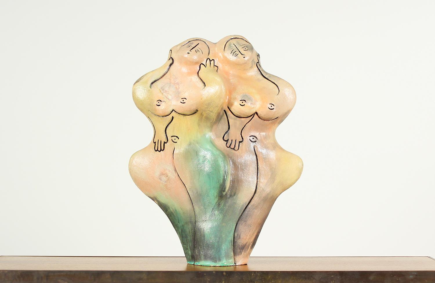 Large free-form female sculpture designed in the United States circa 1960. This interesting art piece features two entwined nude women in earth-toned ceramic. Black lines trace their faces, hands, and bodies. Their facial expressions and body