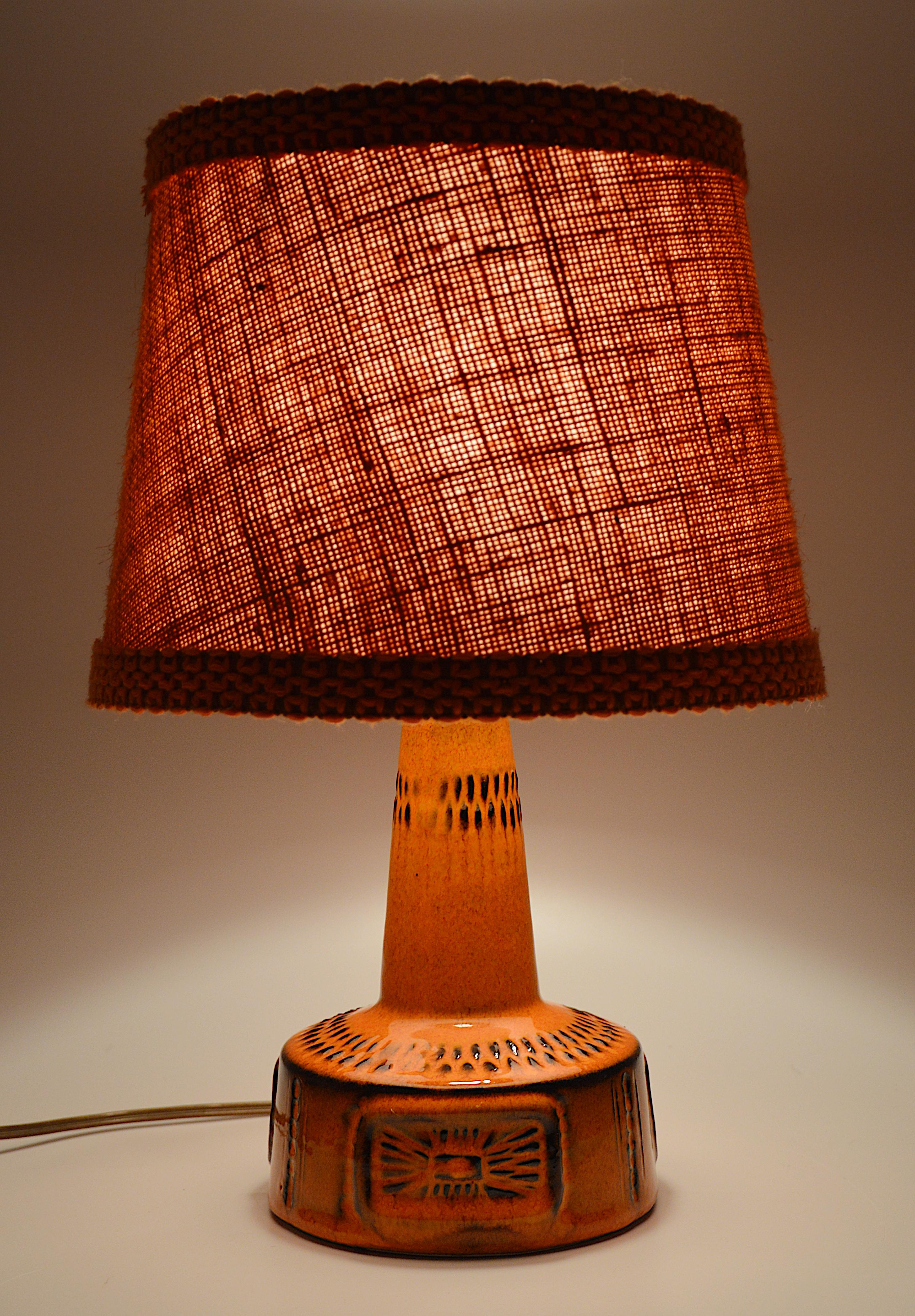 Lampada da tavolo del Medioevo, Germania, anni '60. Questa base in ceramica viene fornita con il suo paralume originale in tessuto. Altezza totale 33,5 cm - 13,2 pollici. Altezza della base in ceramica 16 cm. Diametro completo 22,5 cm - 8,9 pollici.