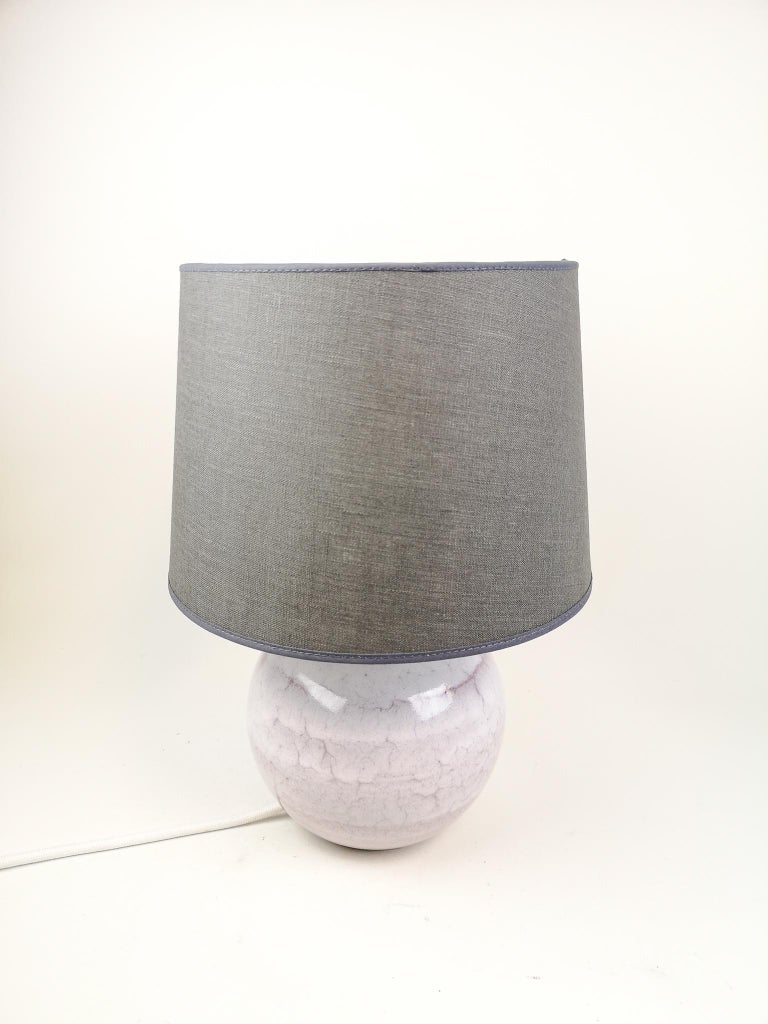 This table lamp was designed by Carl-Harry Stålhane in his studio Designhuset in Lidköping. Its stone wear with a nice pink/white glaze on top. 

In good and working condition. New wiring with a brass holder for the lamp. Not an original shade,