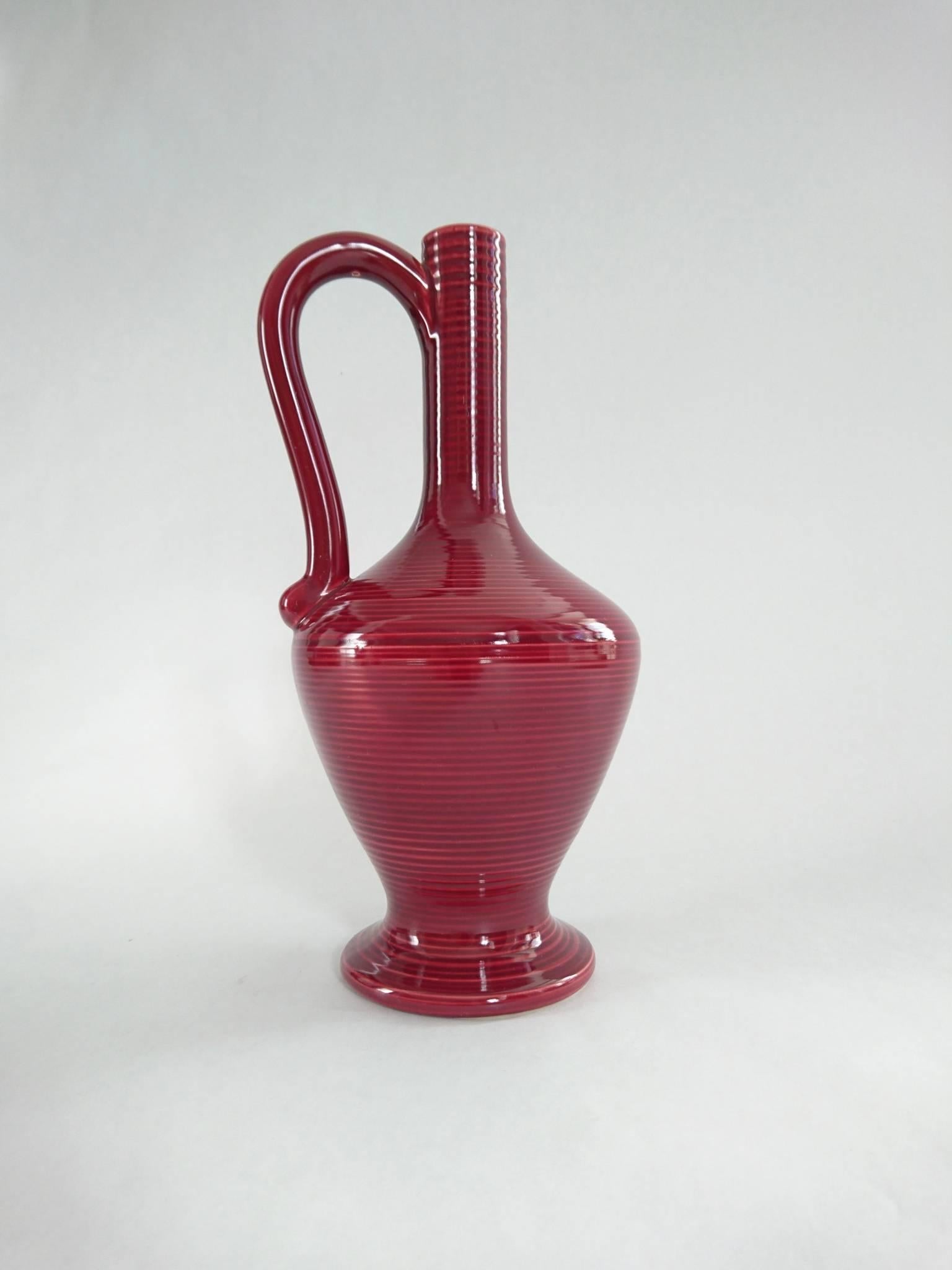 Vase en céramique rouge à rayures horizontales avec poignée, datant du milieu du siècle dernier, produit par Höganäs Keramik, en rayures horizontales d'un rouge profond par Holm et Bjurestig (H et B) entre 1946 et 1956, ce qui correspond à la