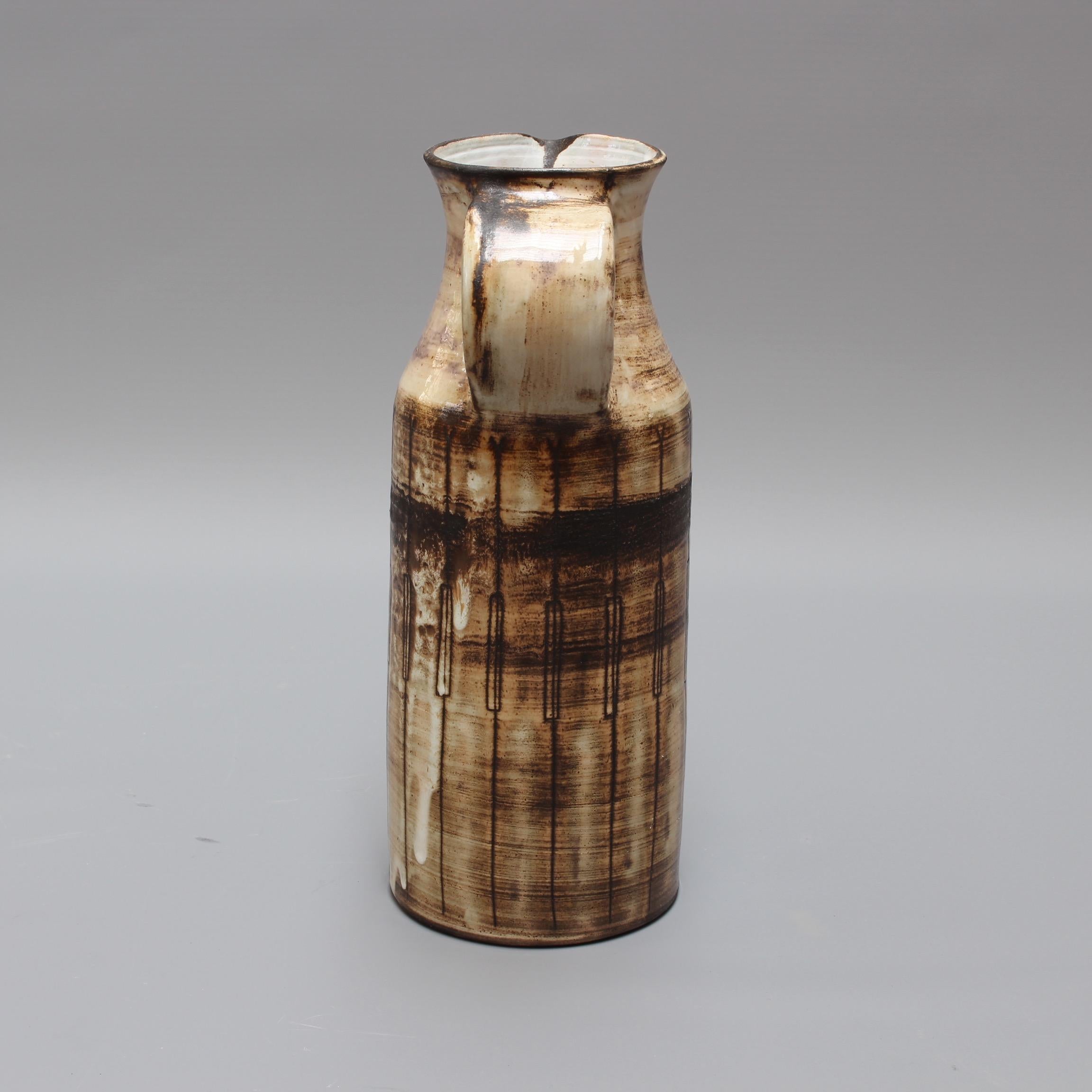 Keramikvase aus der Mitte des Jahrhunderts, um 1960 von Jacques Pouchain (1925-2005). Diese Vase in Form eines Milchkännchens mit der für Pouchain typischen wolkigen Glasur ist stilvoll, charaktervoll und substanziell. Pouchain fügte vertikale