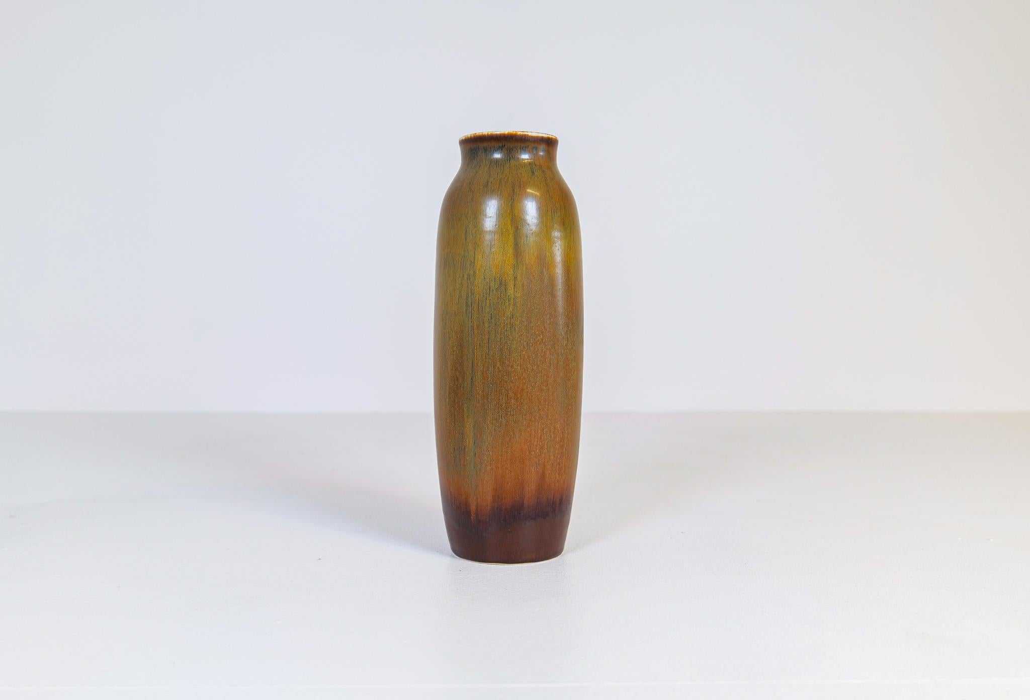 Diese wunderbare skulpturale Vase mit ihrer intensiven Harfur-Glasur, die in verschiedenen Farben changiert, wurde von Rörstrand Schweden hergestellt und von Carl-Harry Stålhane entworfen. 

Sehr guter Zustand.

Maße: H 31 cm, B 11 cm.
  