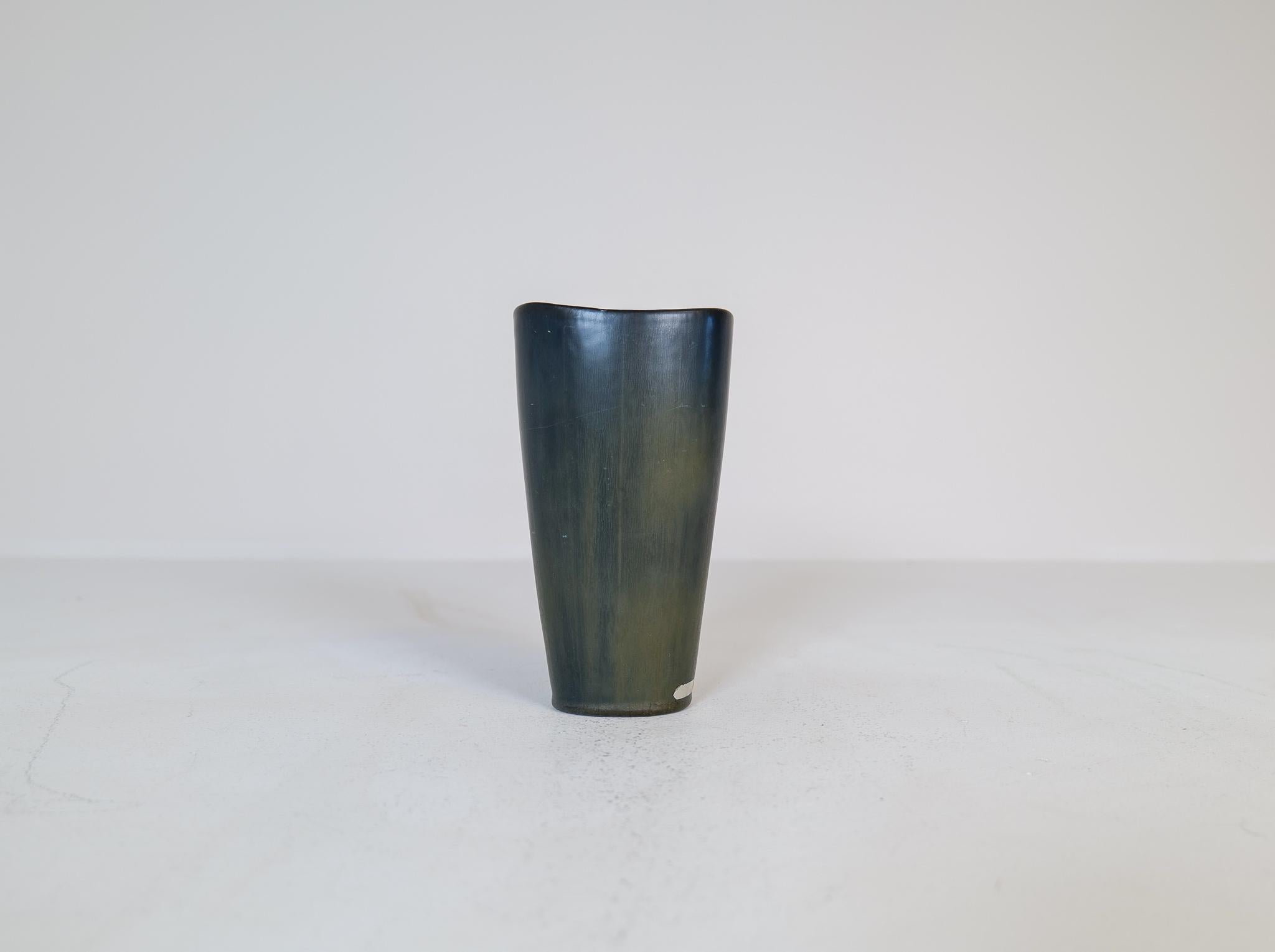 Ce vase fantastique a été fabriqué en Suède dans les années 1950 à Rörstrand et conçu par Gunnar Nylund. 
Magnifique par sa glaçure changeante (noire et verte) et sa forme étonnante. 

Bon état. 

Mesures : H 21 cm, D 11 cm.
 