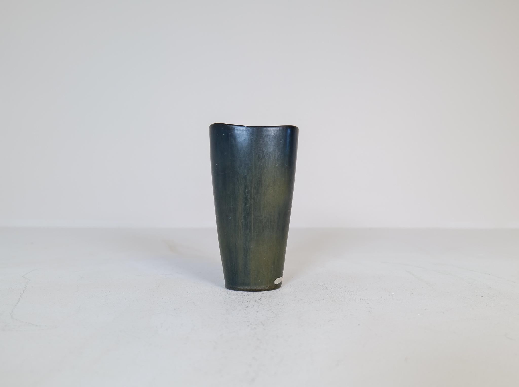 Questo fantastico vaso è stato realizzato in Svezia negli anni '50 da Rörstrand e disegnato da Gunnar Nylund. 
Bellissimo per il suo colore mutevole dello smalto (nero e verde) e per la sua forma stupefacente. 

Buone condizioni. 

Misure: H.