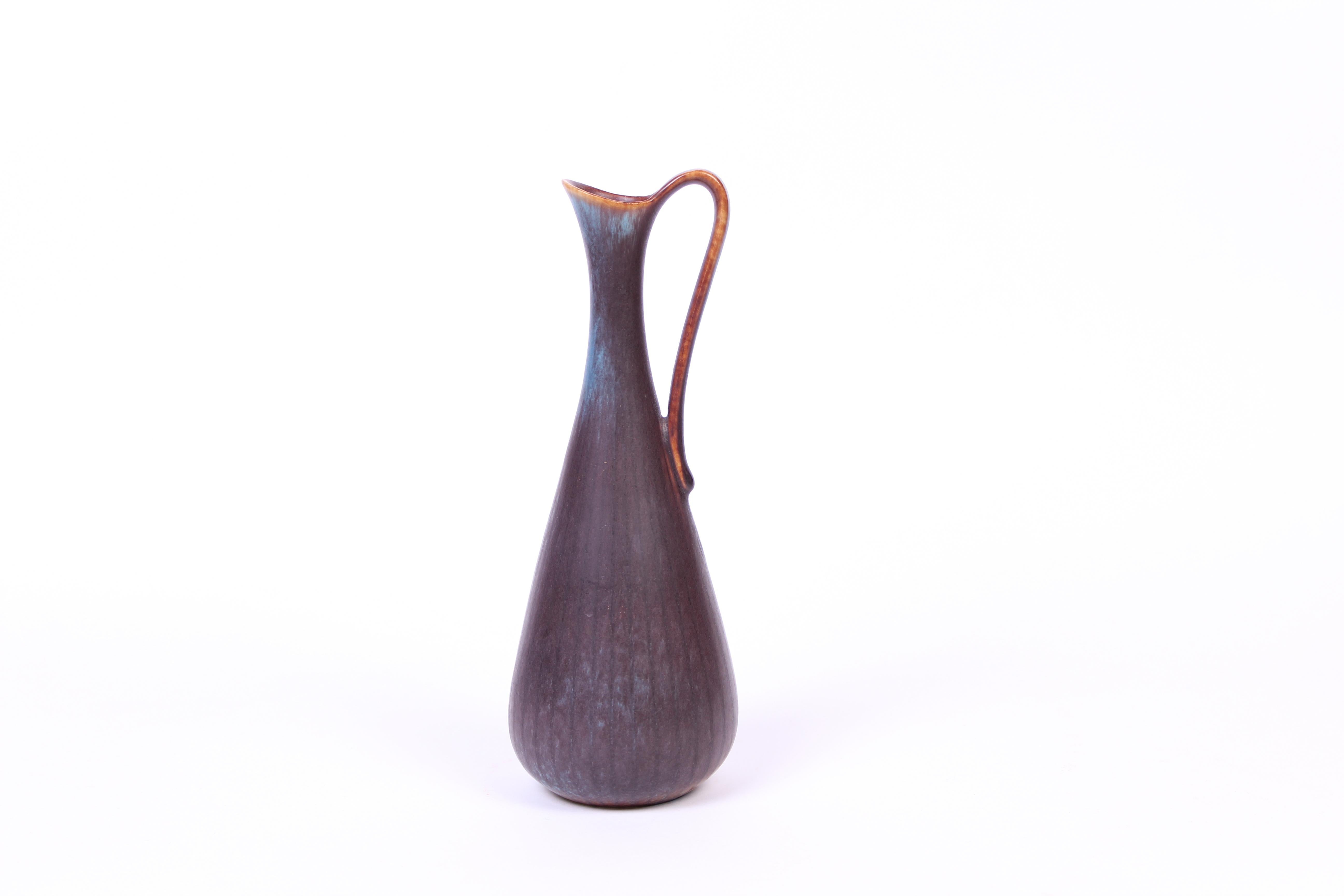 A midcentury ceramic vase with handle designed by Gunnar Nylund for Rörstrand. Excellent vintage condition with minor signs of usage.