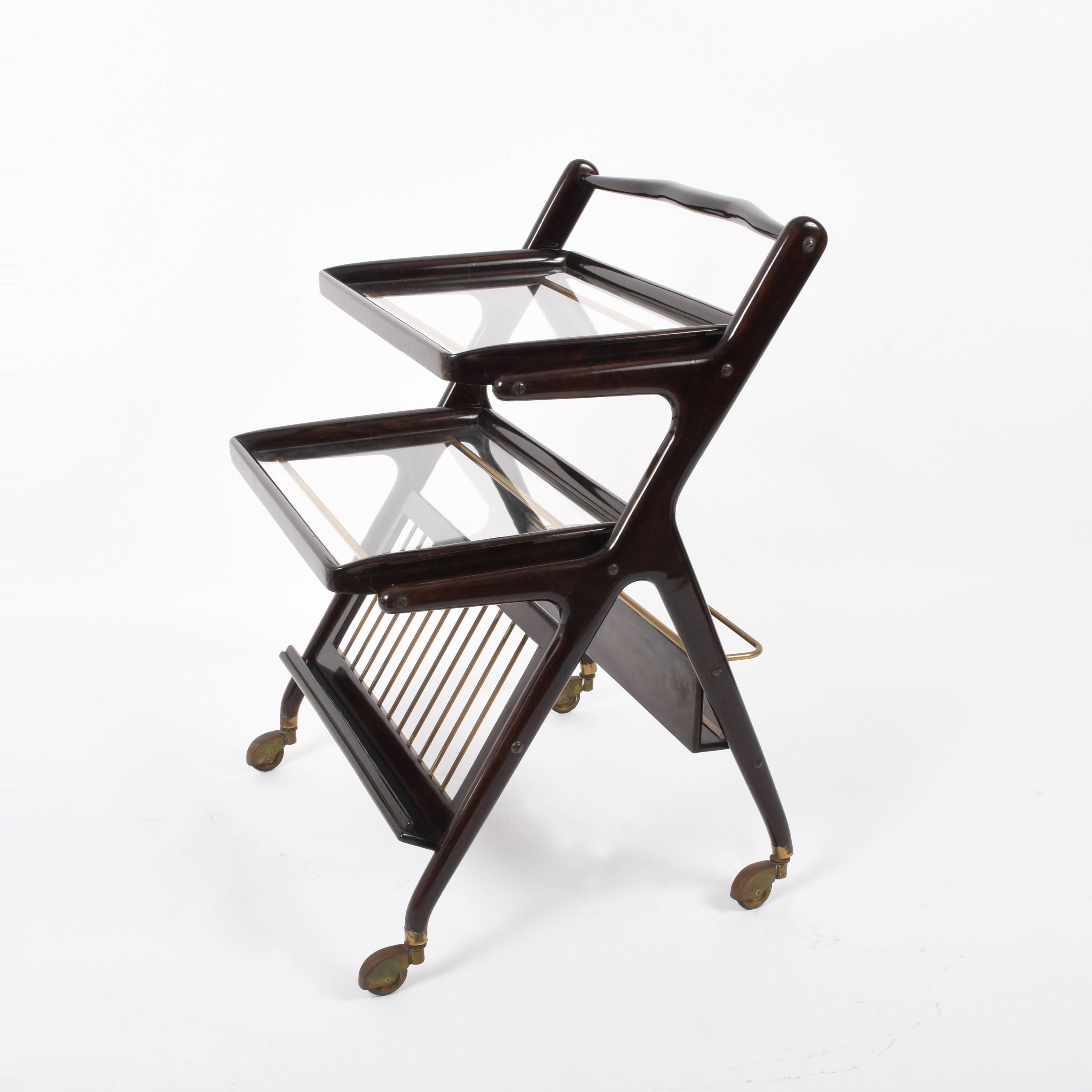 Fantastic midcentury wood bar trolley. It was produced by Cesare Lacca in Italy during 1950s. 

This wonderful piece comes with two glass removable trays and an ergonomic bottle rack.

The lines of this piece make it perfect for a midcentury-style