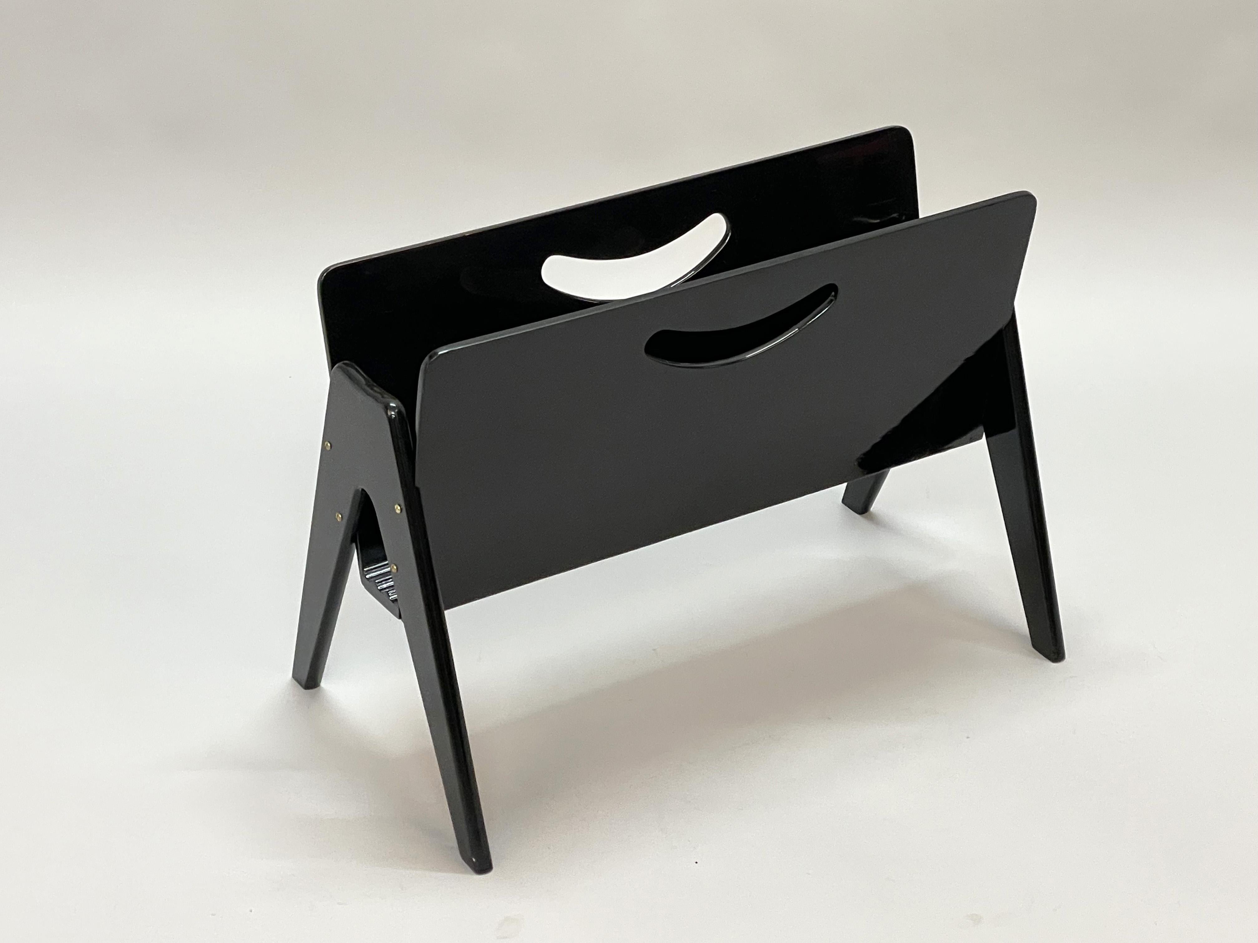 Wonderful mid-century black lacquered beech wood magazine rack. It was designed by Cesare Lacca produced in Milan, Italy in the 1950s.

It is both elegant and functional, as black lacquered wood blends seamlessly creating a striking mid-century