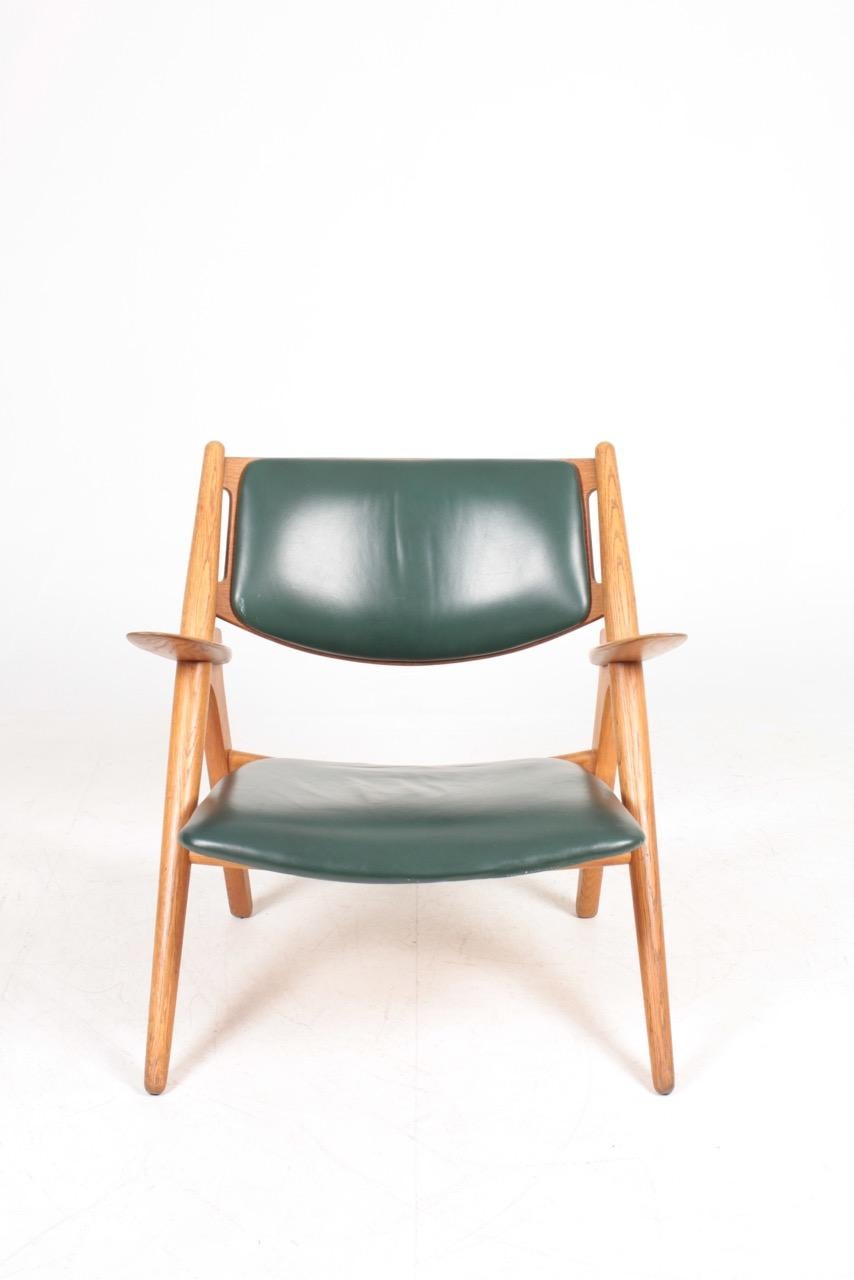 Lounge chair in oak and patinated leather. Designed by Hans J. Wegner M.A.A for Carl Hansen furniture. Great original condition. Made in Denmark.