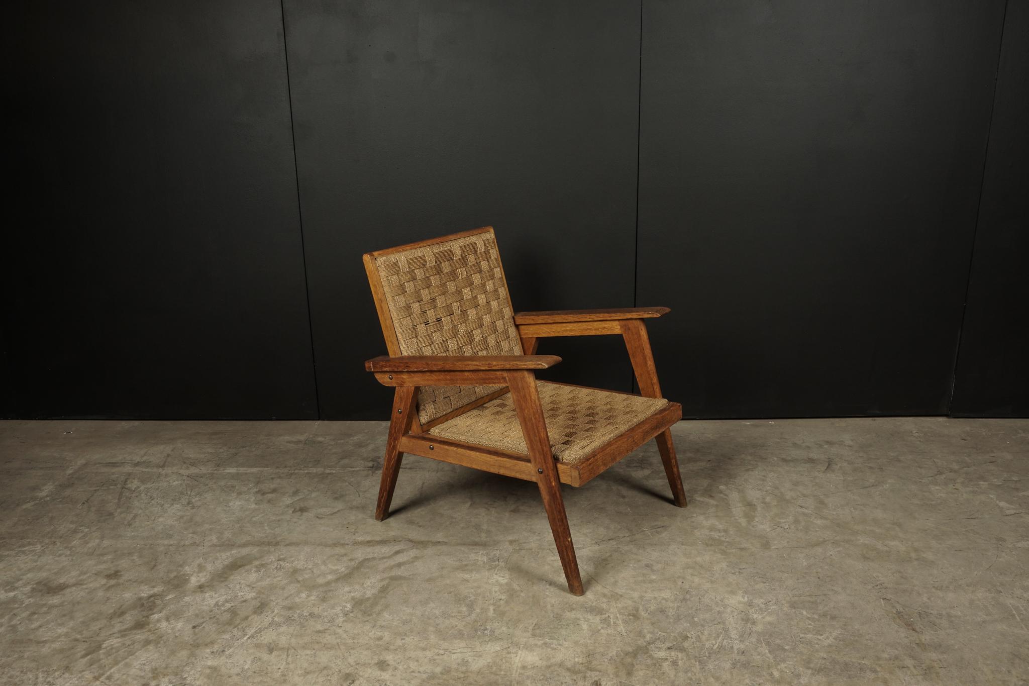 Midcentury chair from France, circa, 1970. Solid oak construction with woven rush seat and back.